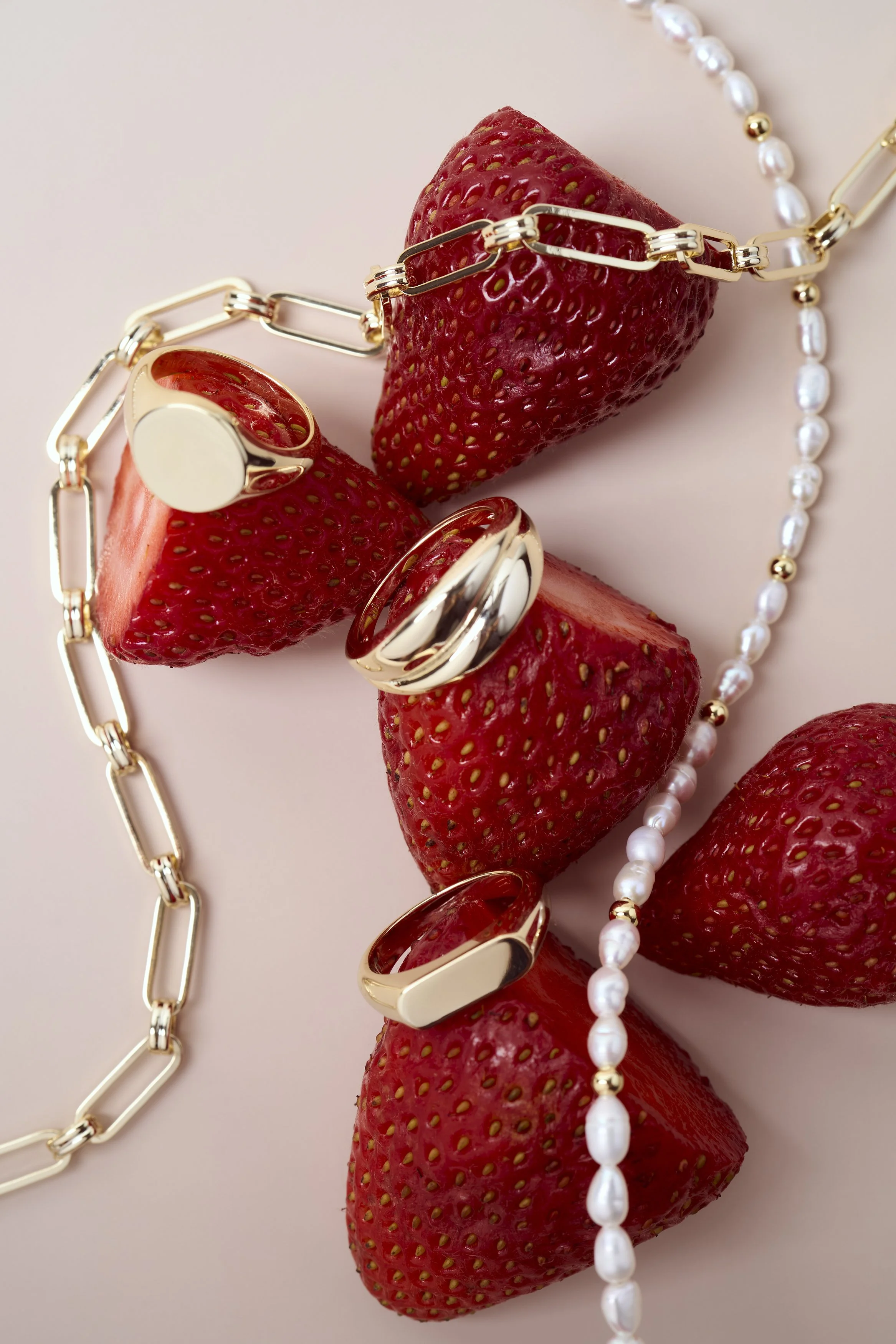 fotografia minimalista de producto, fotografía aros, fotografia joyas, dorado, aros, oro, collares, frutillas, perlas