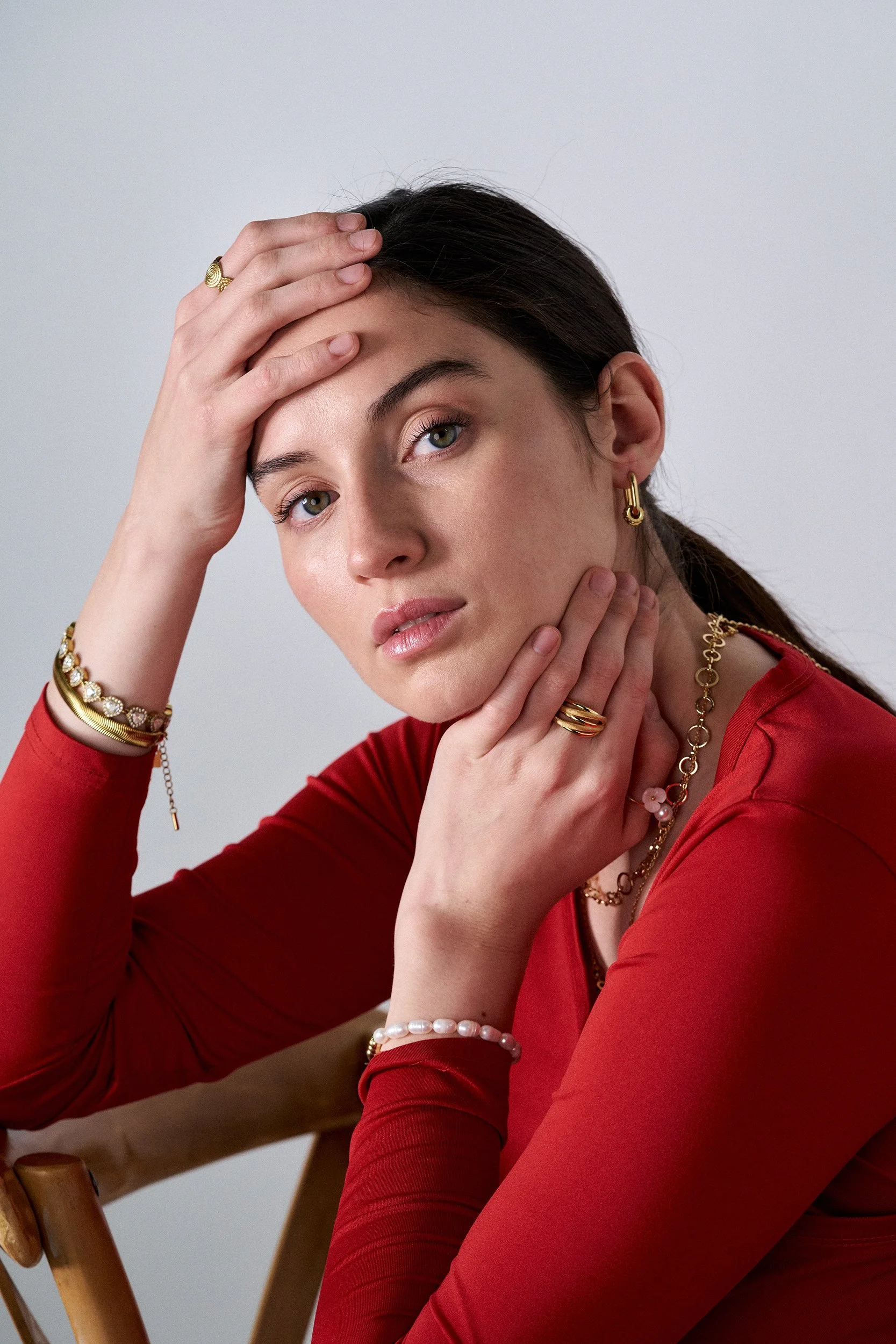 mujer modelando joyas, fotografia editorial, iluminación tenue, joyas de plata, joyas de oro