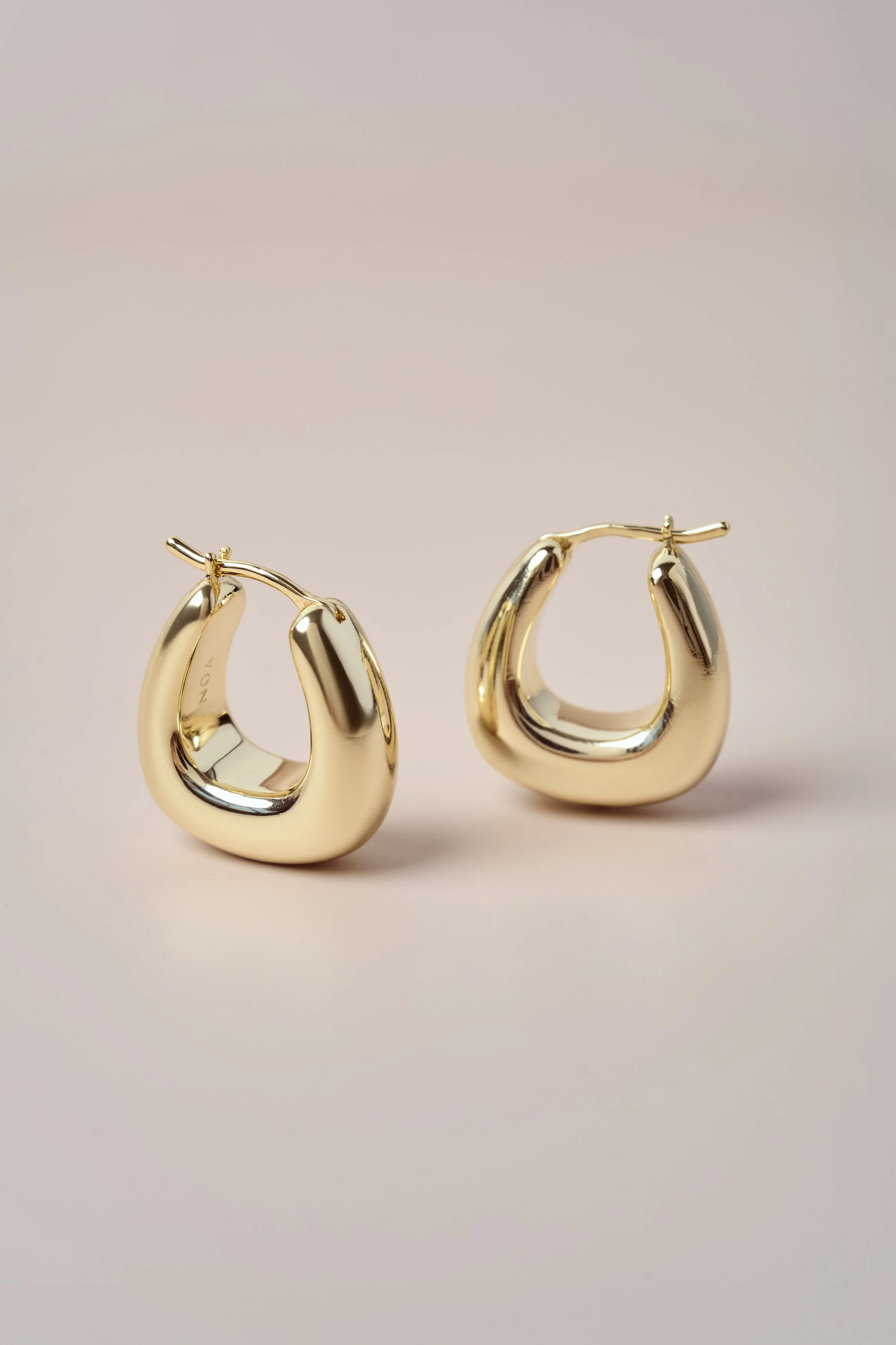 fotografia minimalista de producto, fotografía aros, fotografia joyas, dorado, aros, oro