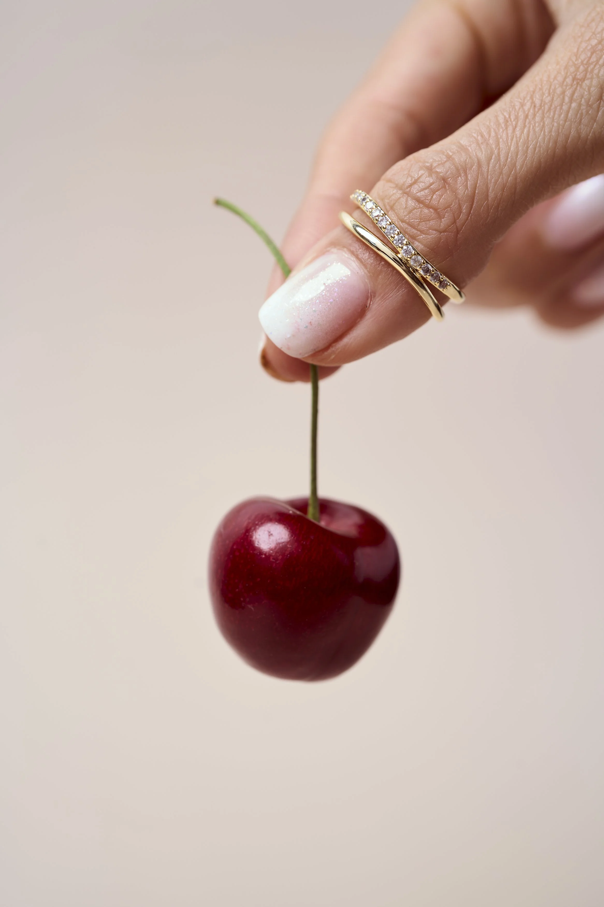 fotografia minimalista de producto, fotografía aros, fotografia joyas, dorado, aros, oro, collares, guindas, cerezas , perlas