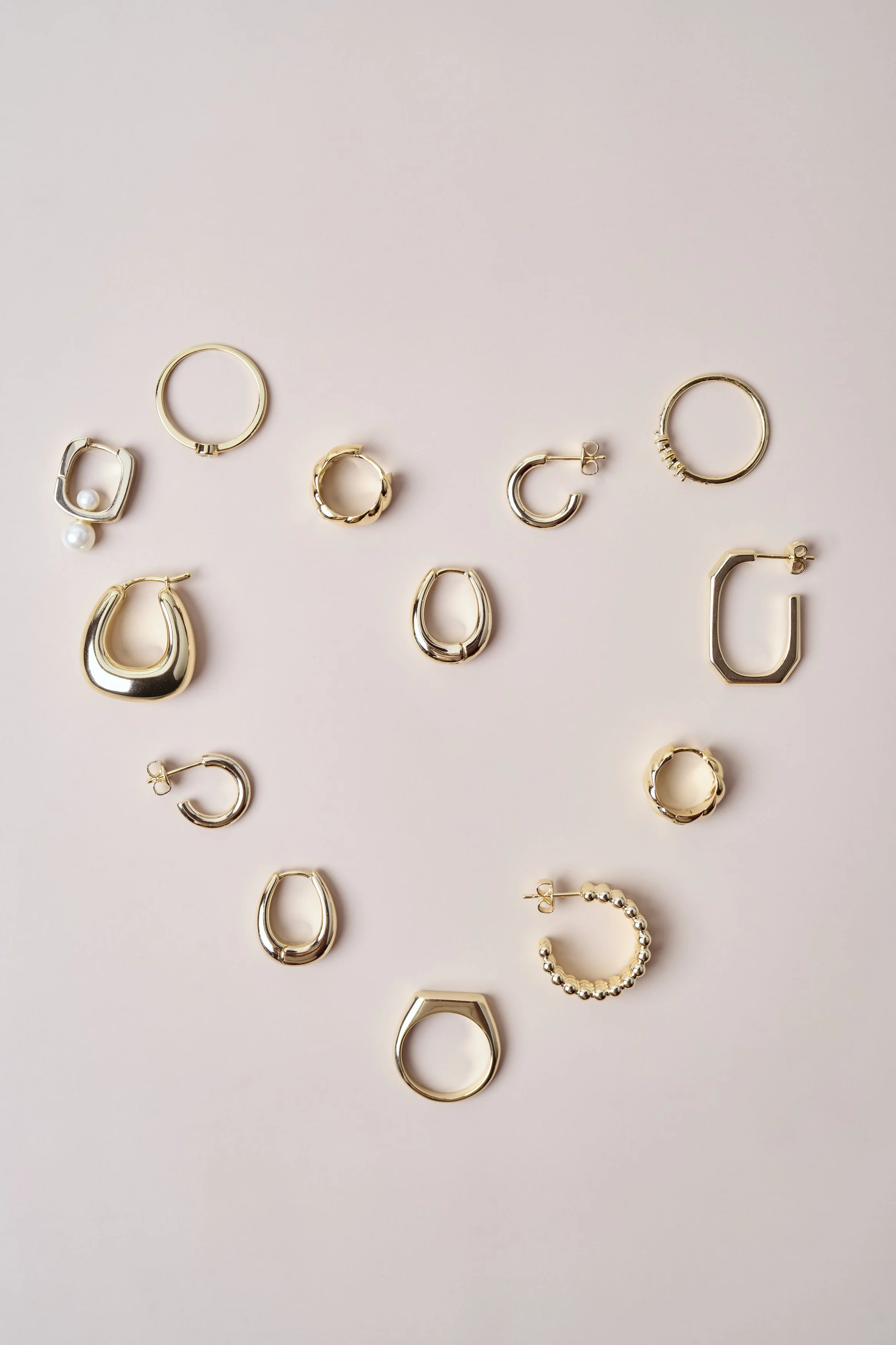 fotografia minimalista de producto, fotografía aros, fotografia joyas, dorado, aros, oro, collares, frutillas, perlas