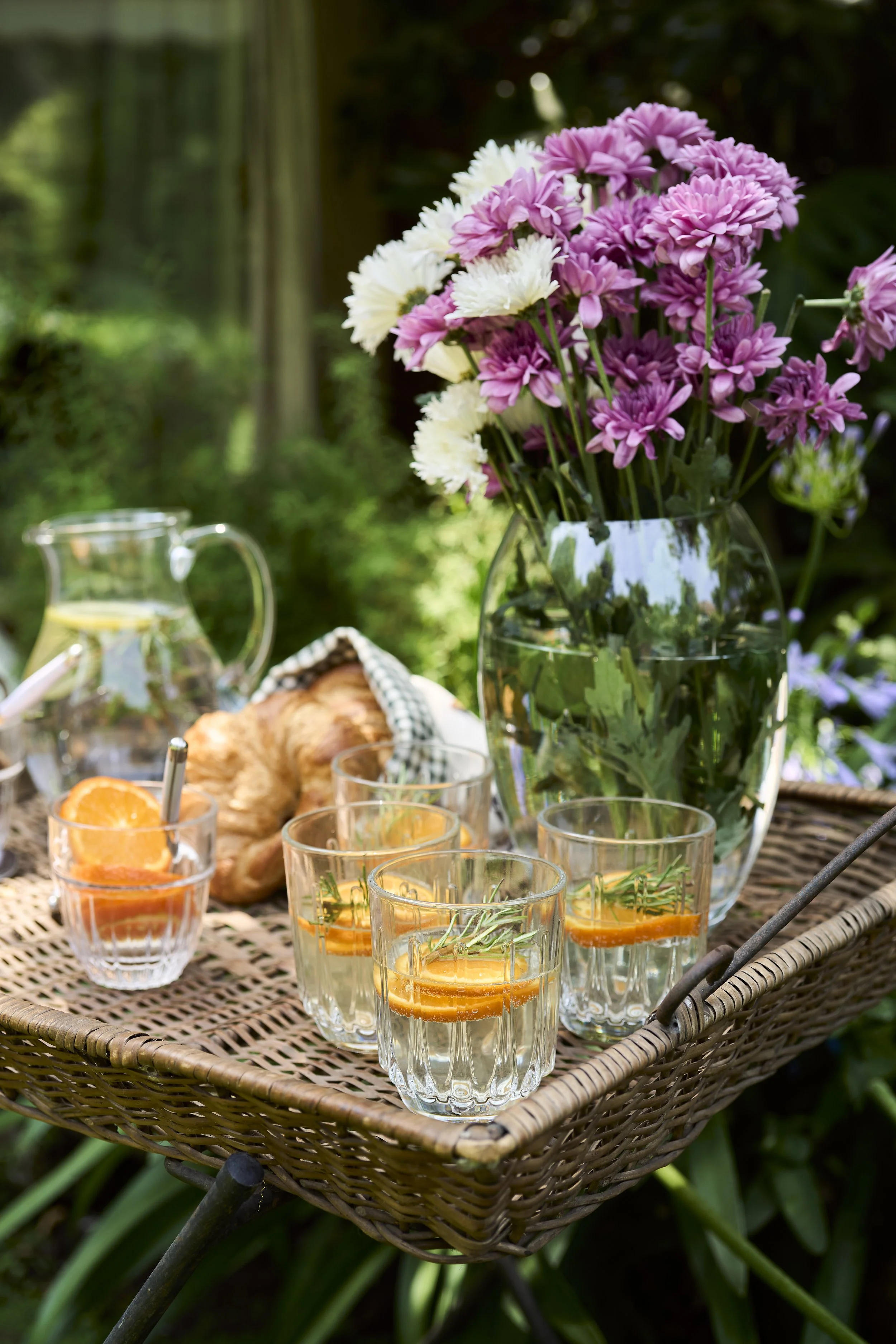 Fotografía de producto lifestyle con mesa de terraza, copas y tablas de cóctel al aire libre.