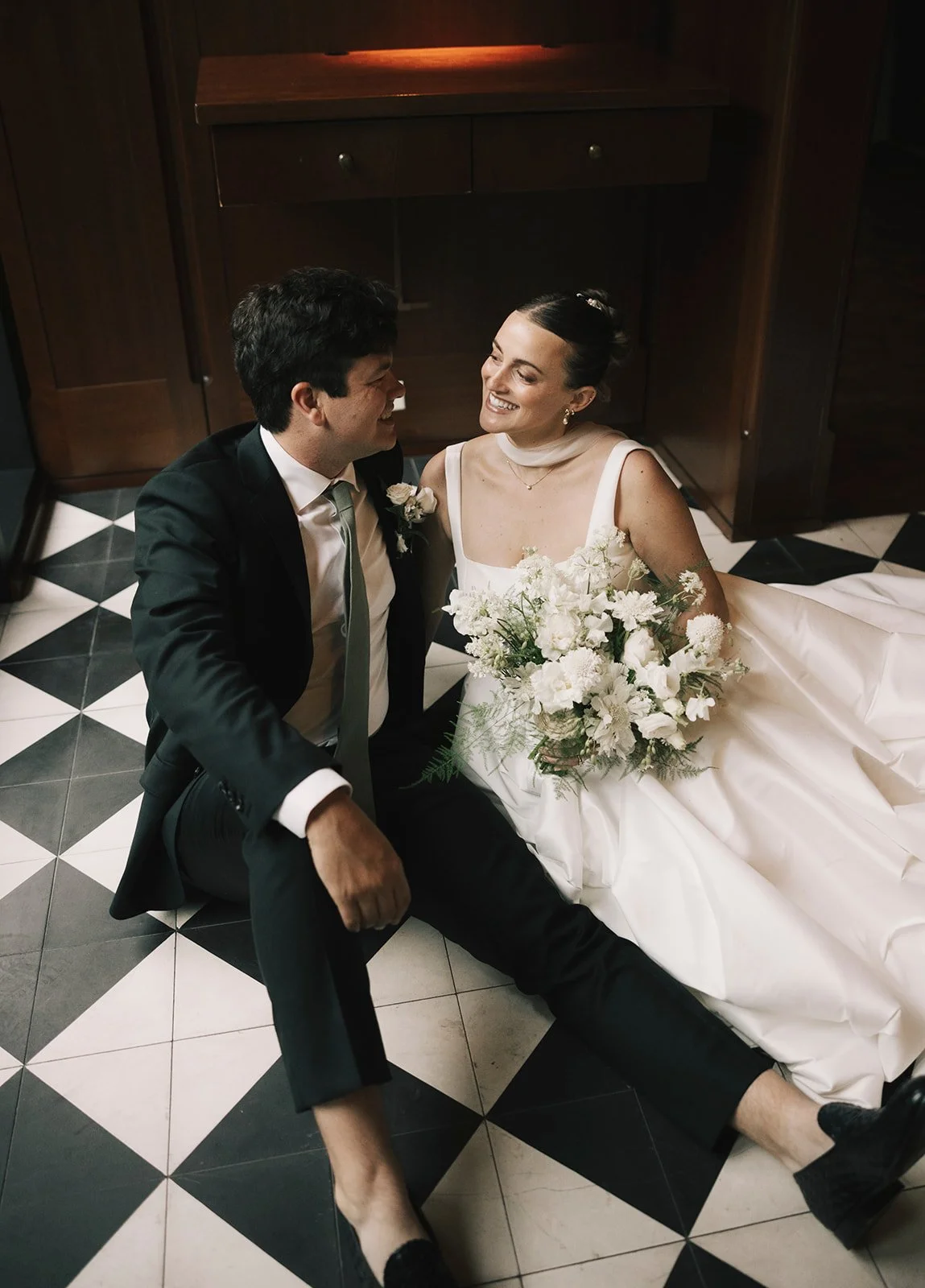 couple taking photos on a black and white checkered floor