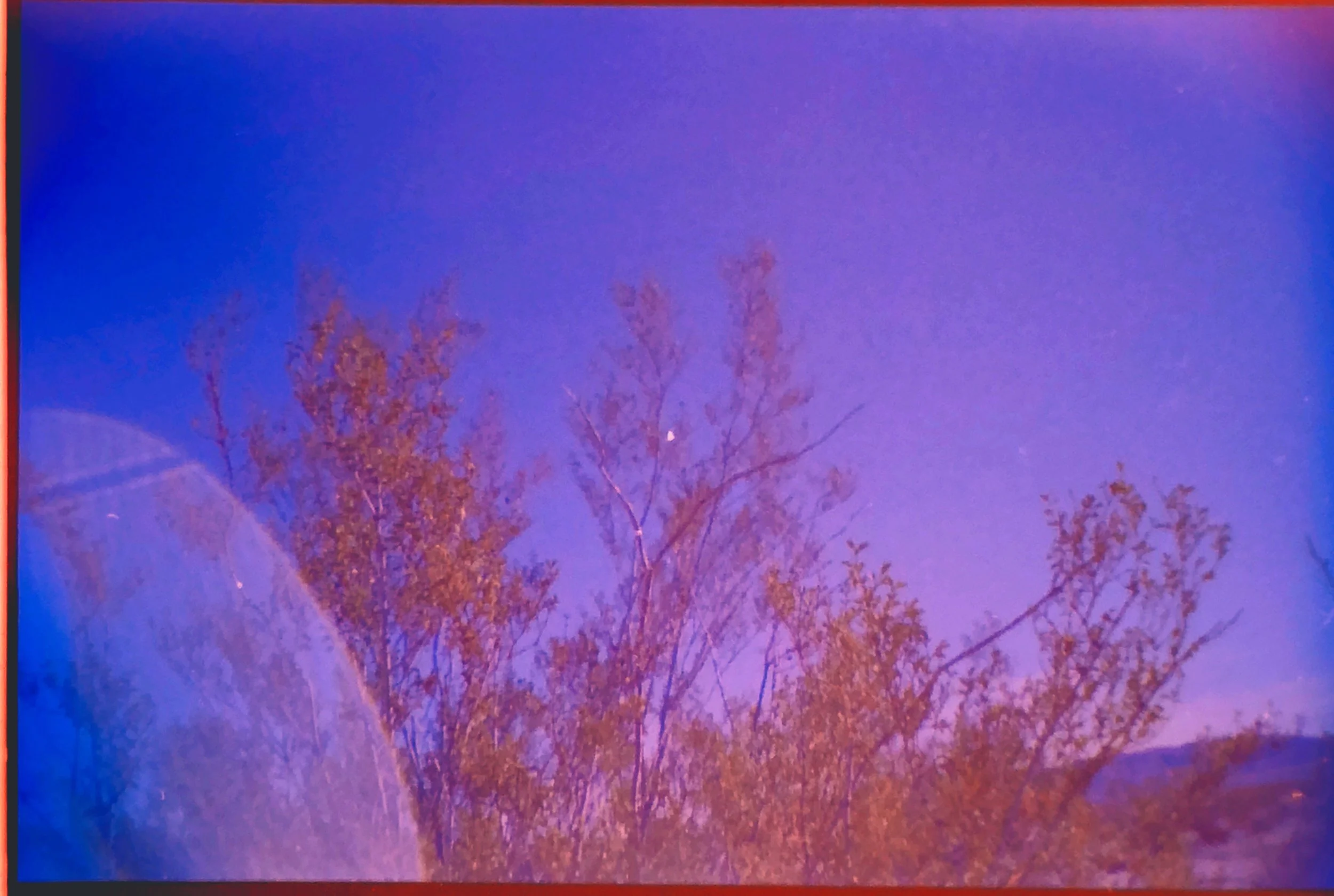creosote on sardina camera with light leak and full moon - cross processed color slide film