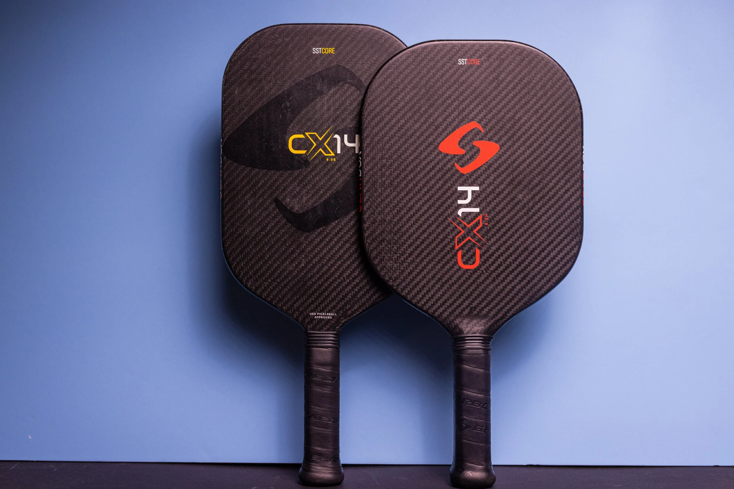 Gearbox CX14E and CX14 pickleball paddles side by side with carbon fiber faces