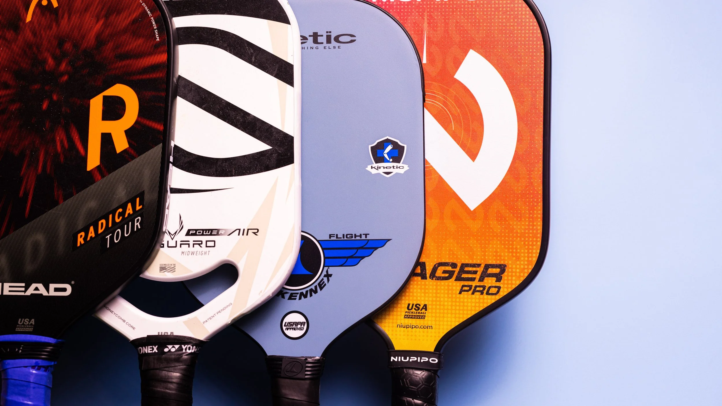 Collection of pickleball paddles with different face materials including Head Radical Tour, Power Air, Pro Kennex Flight, and Niupipo Voyager Pro