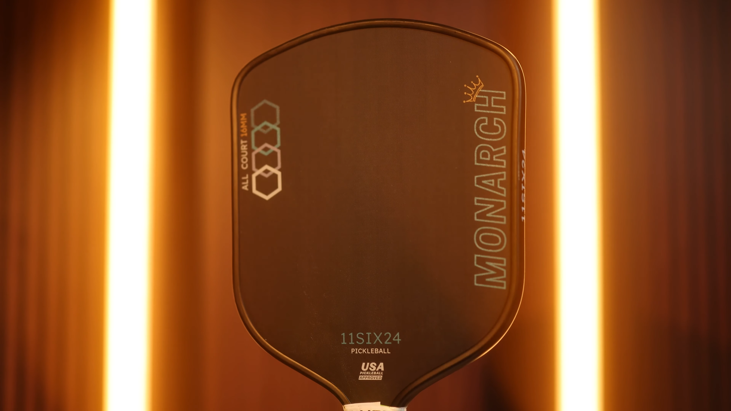 11SIX24 Monarch All Court pickleball paddle front view with dramatic amber lighting