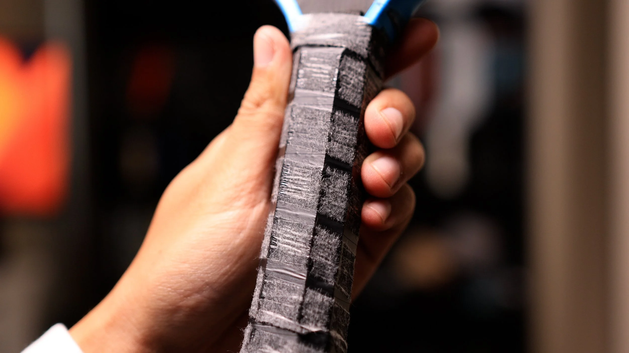 Close-up of pickleball paddle handle with lead tape wrap for added weight