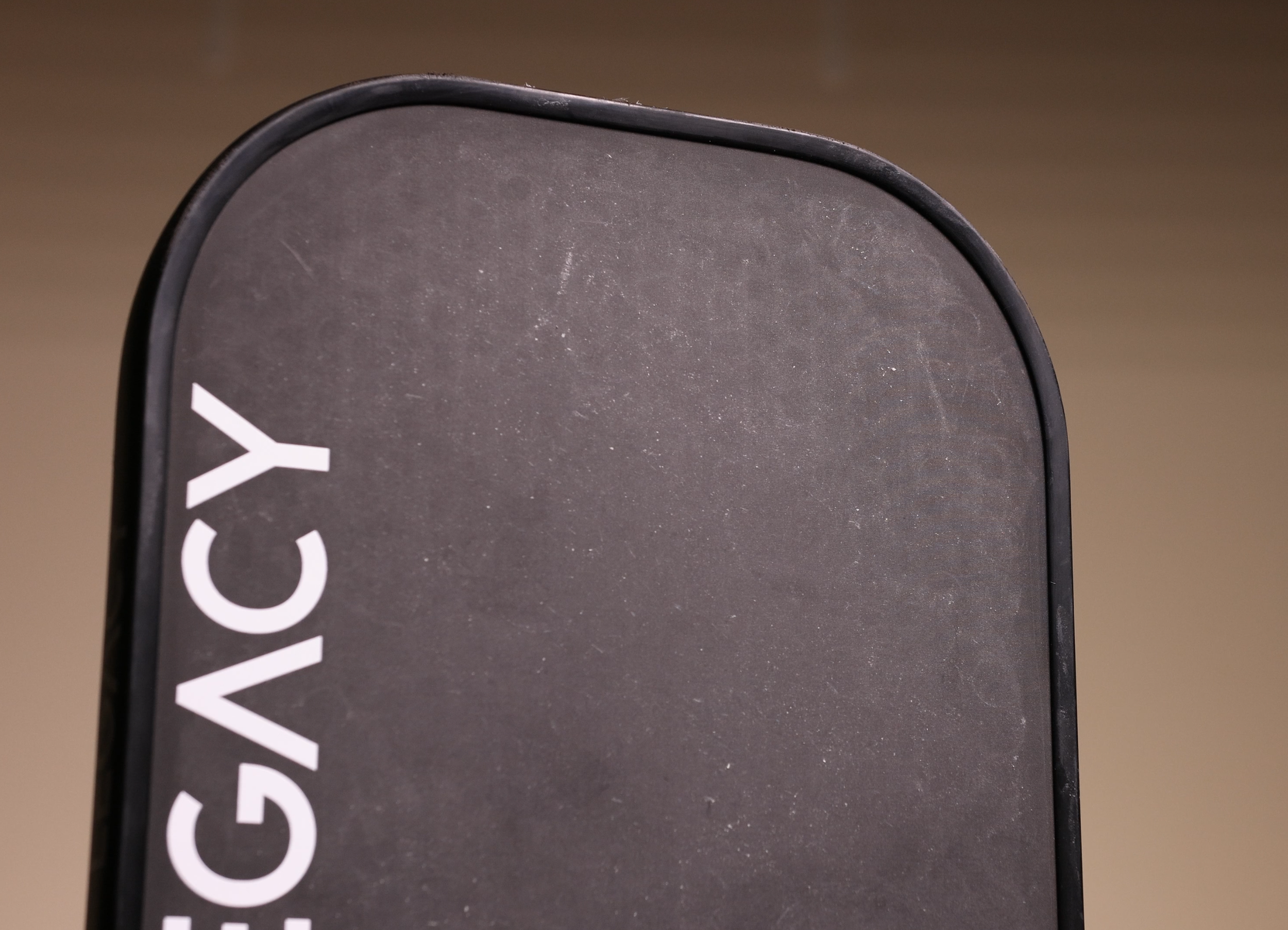 Legacy Pro pickleball paddle face showing scratches and surface wear from court testing