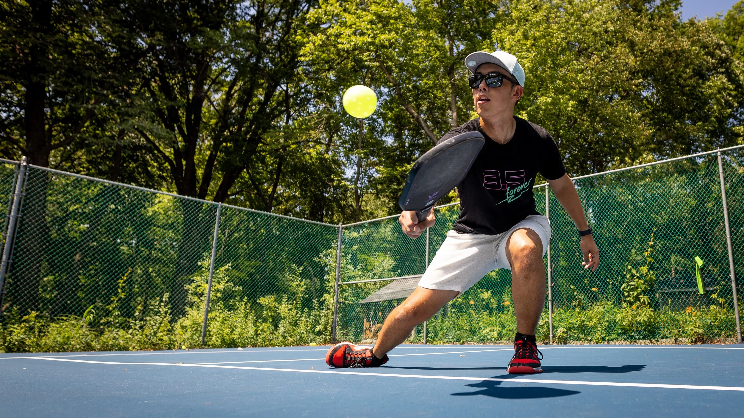 Player driving a forehand with the Vatic Pro Prism pickleball paddle on an outdoor court
