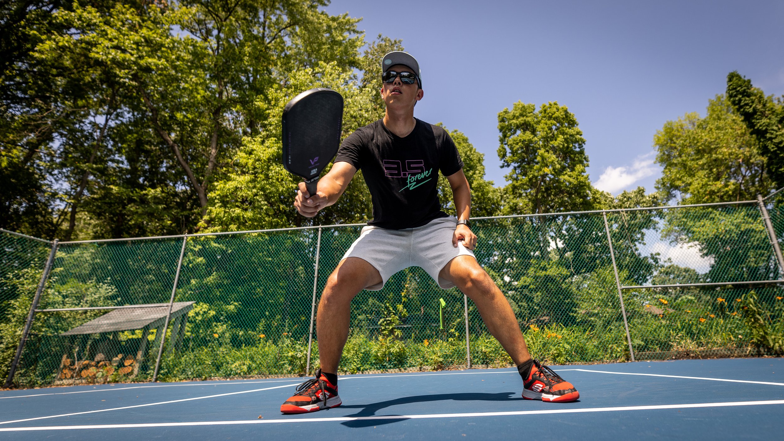 Player in ready position holding the Vatic Pro Prism pickleball paddle on an outdoor court