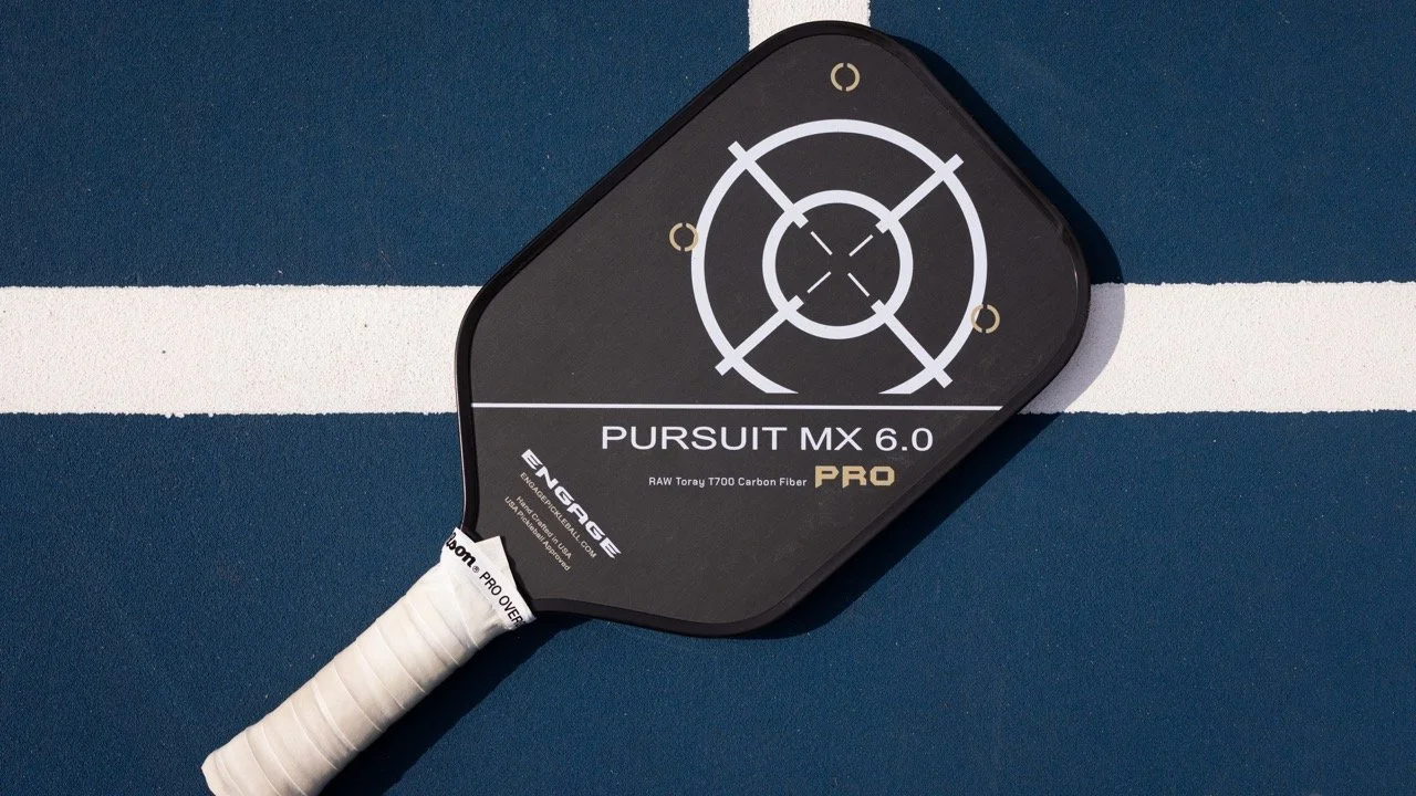 Engage Pursuit MX 6.0 Pro pickleball paddle on a blue court with T700 carbon fiber face