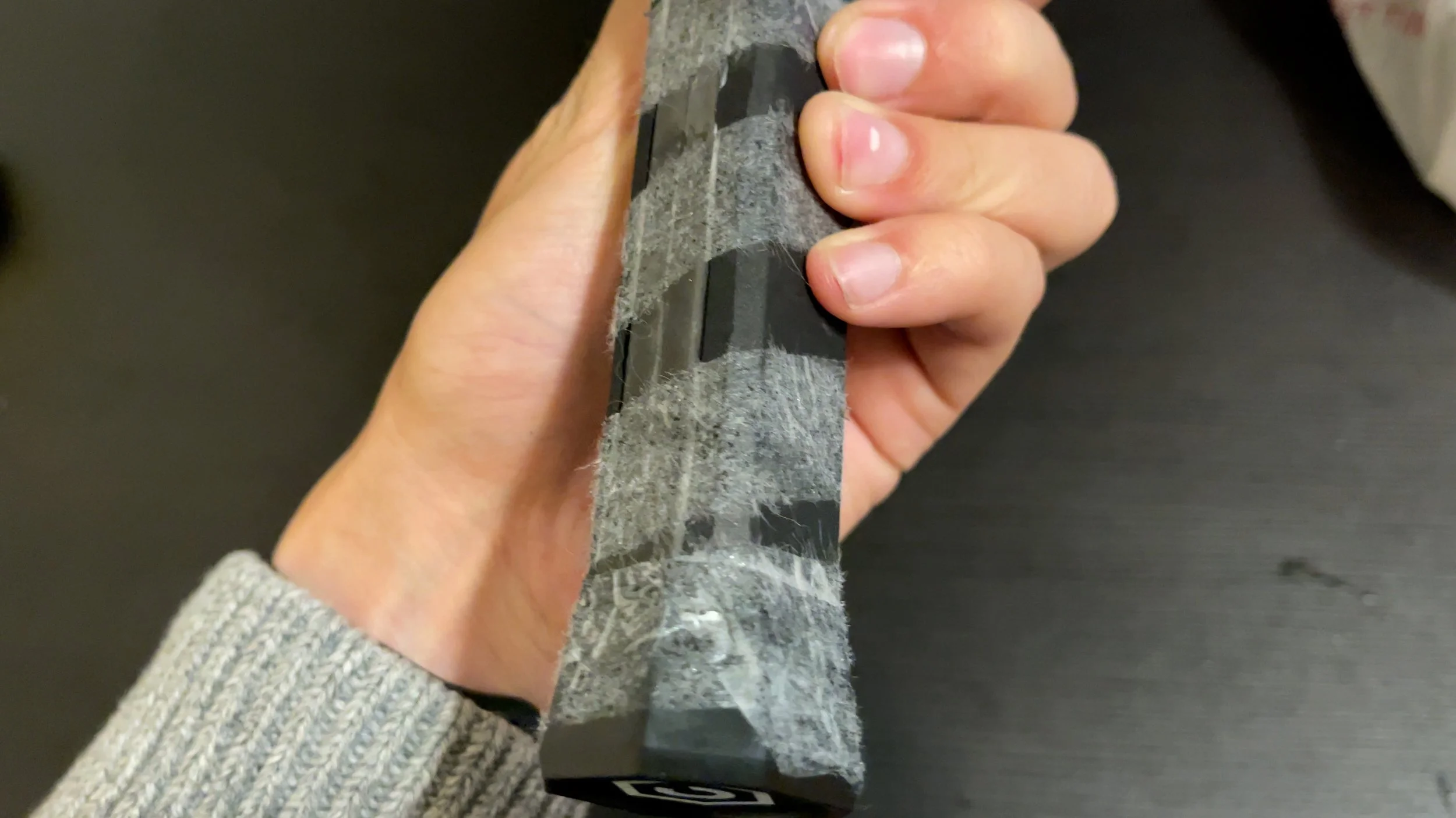 CRBN 2X pickleball paddle handle close-up showing carbon fiber layup and grip wrapping