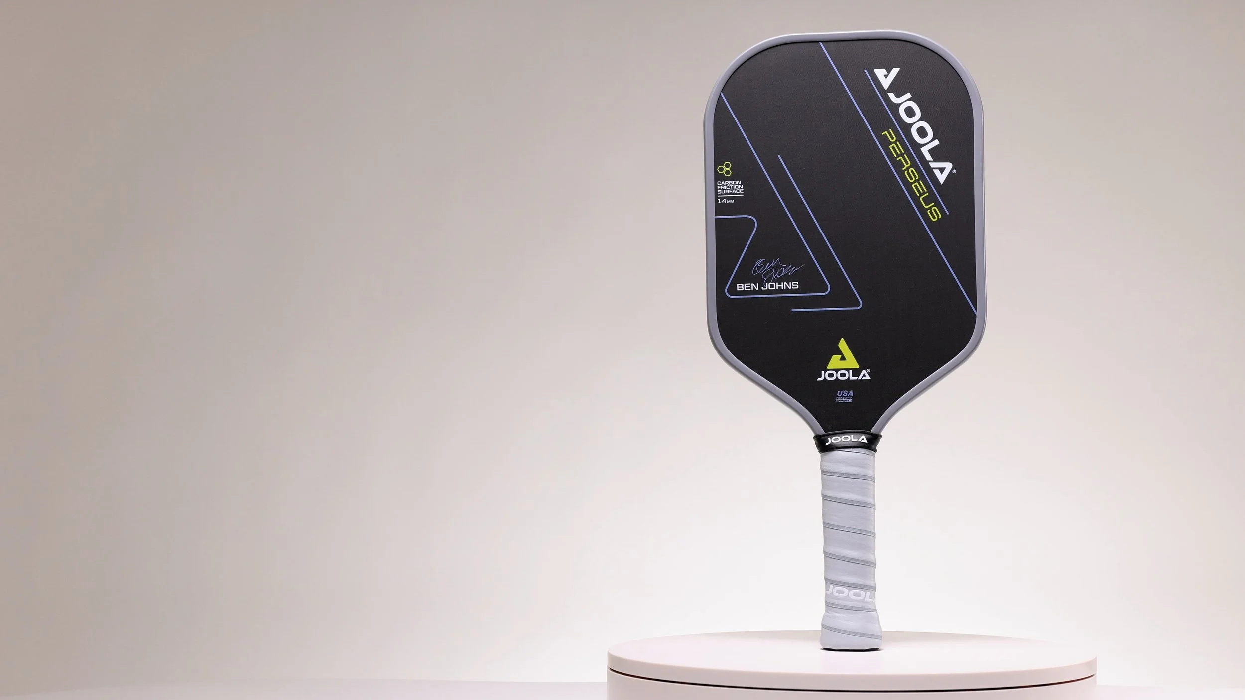JOOLA Ben Johns Perseus pickleball paddle on a display stand showing full front face design