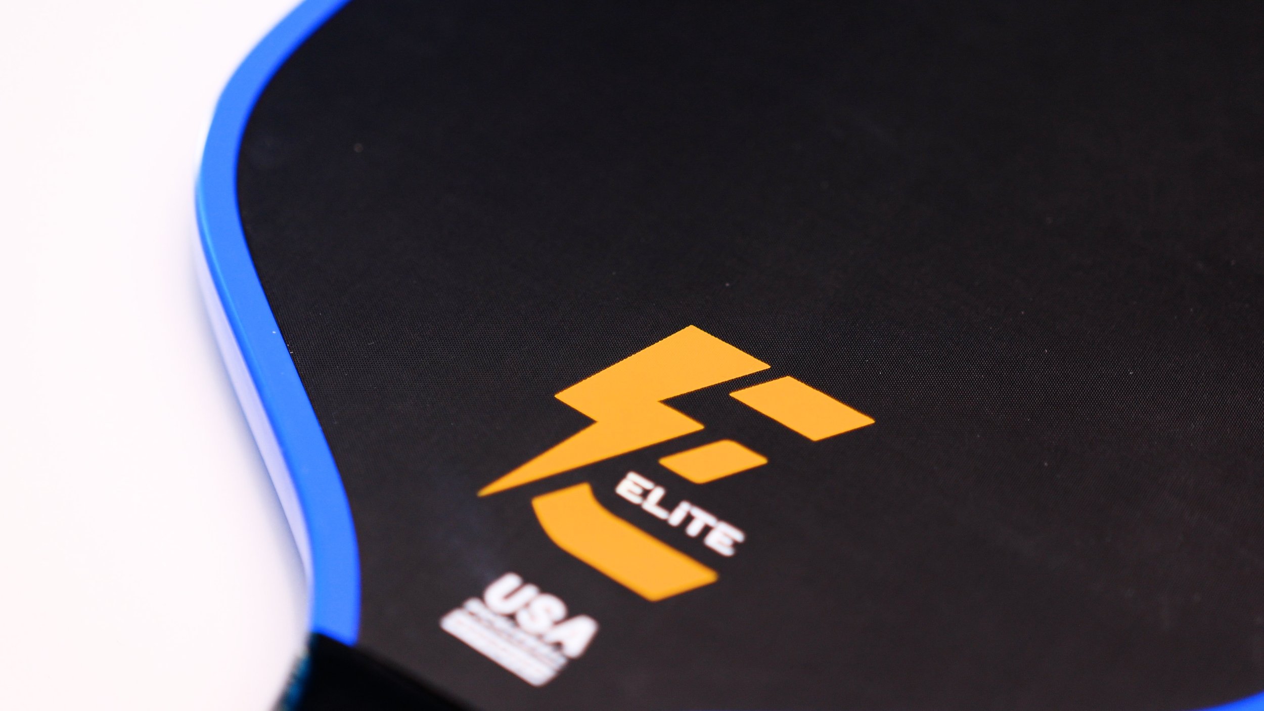 Electrum Model E Elite pickleball paddle face close-up showing carbon fiber texture and Elite branding