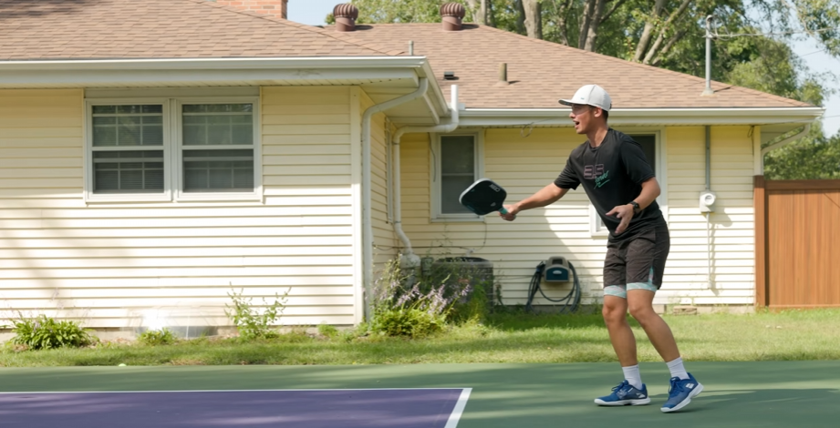 Player hitting a forehand on a backyard pickleball court with CRBN Waves paddle