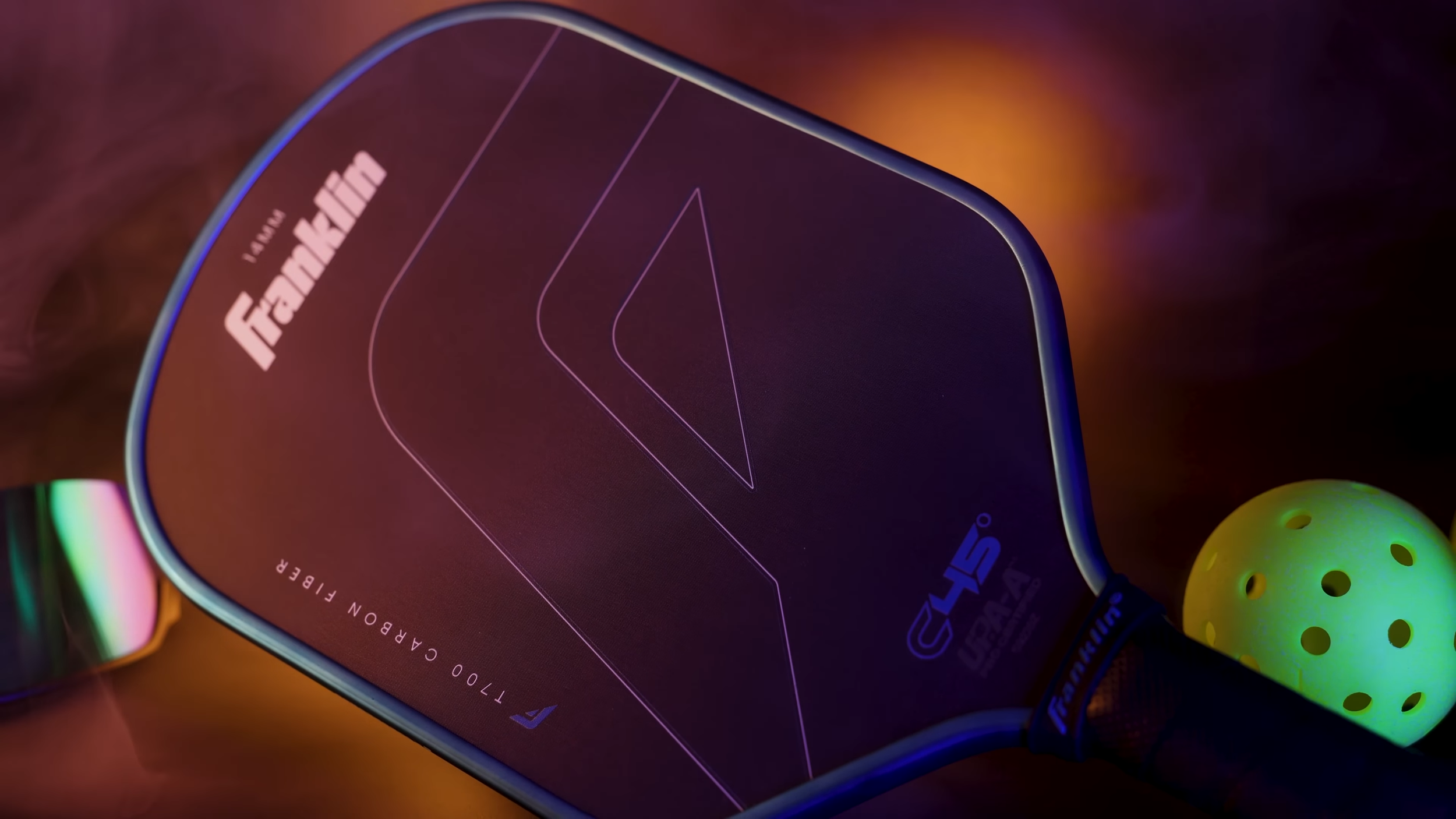 Franklin C45 pickleball paddle with T700 carbon fiber face shown in dramatic purple and orange lighting