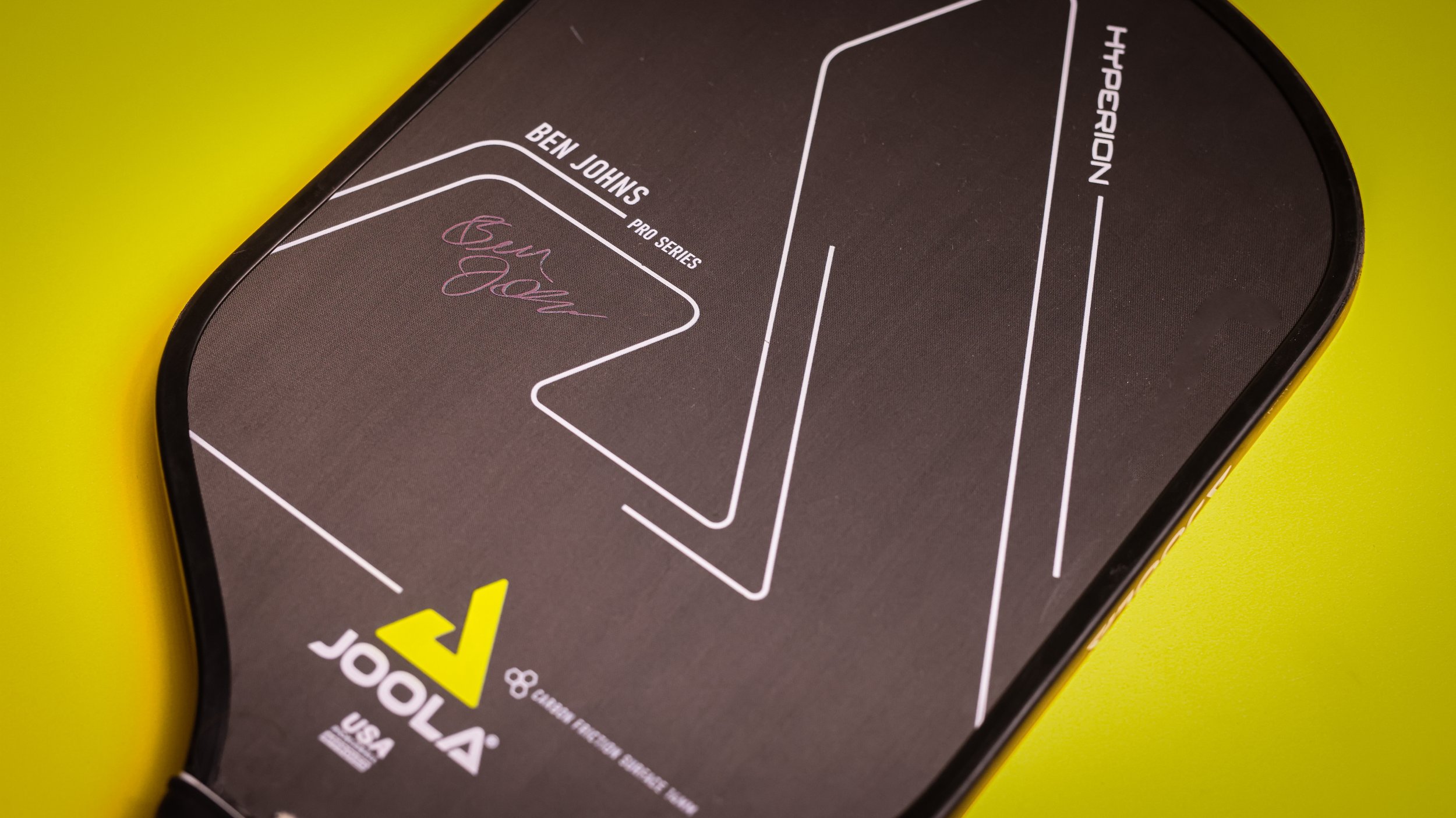 JOOLA Ben Johns Hyperion CFS pickleball paddle face close-up on a yellow background