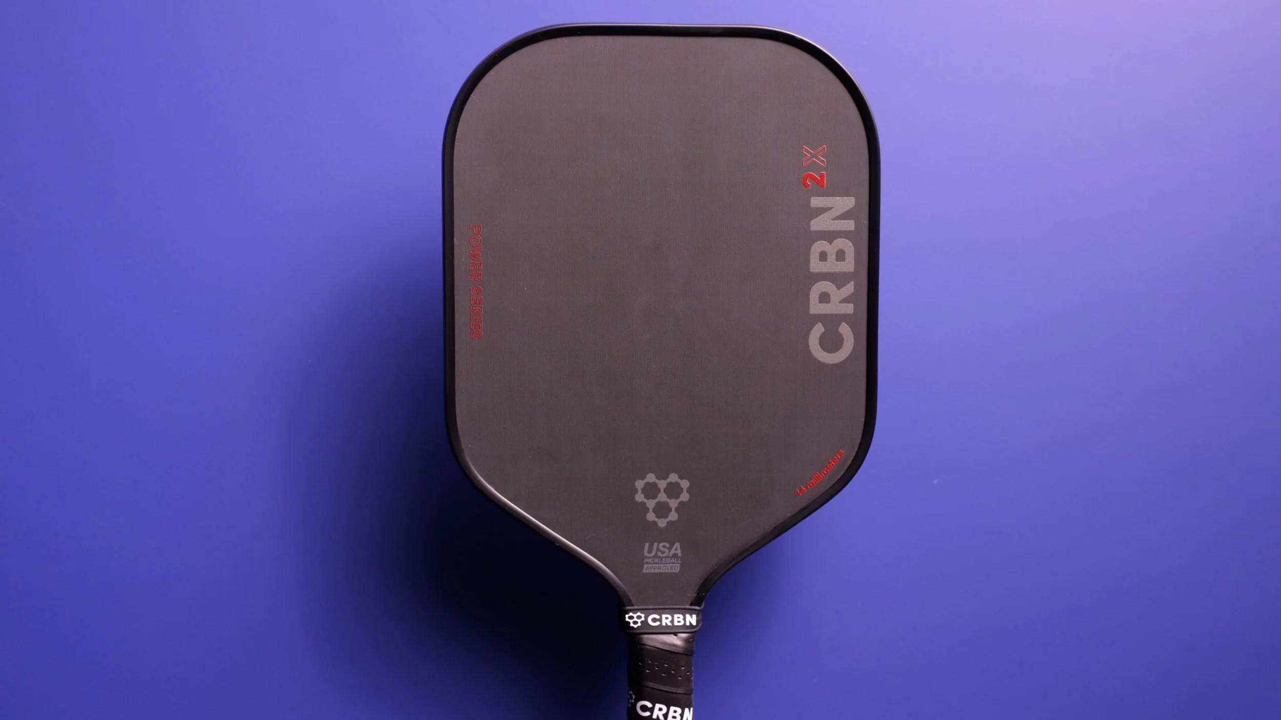 CRBN 2X 16mm pickleball paddle front face view on purple background showing wider body shape