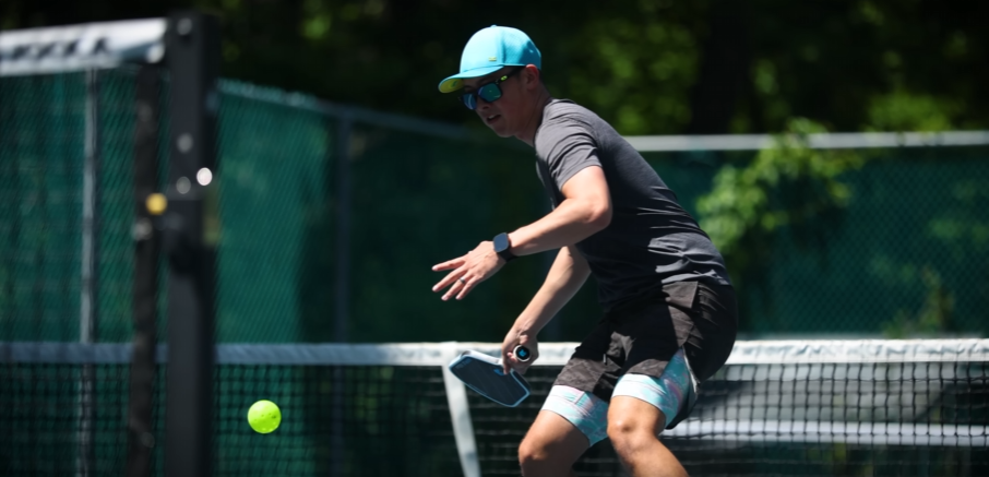 Player hitting a shot at the net with a Ronbus Ripple V2 pickleball paddle on an outdoor court