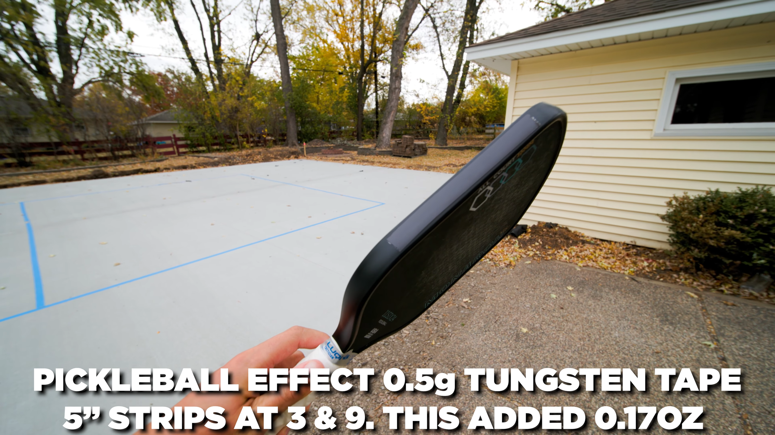 11SIX24 Monarch All Court pickleball paddle held courtside with tungsten tape weight setup applied at 3 and 9 o'clock