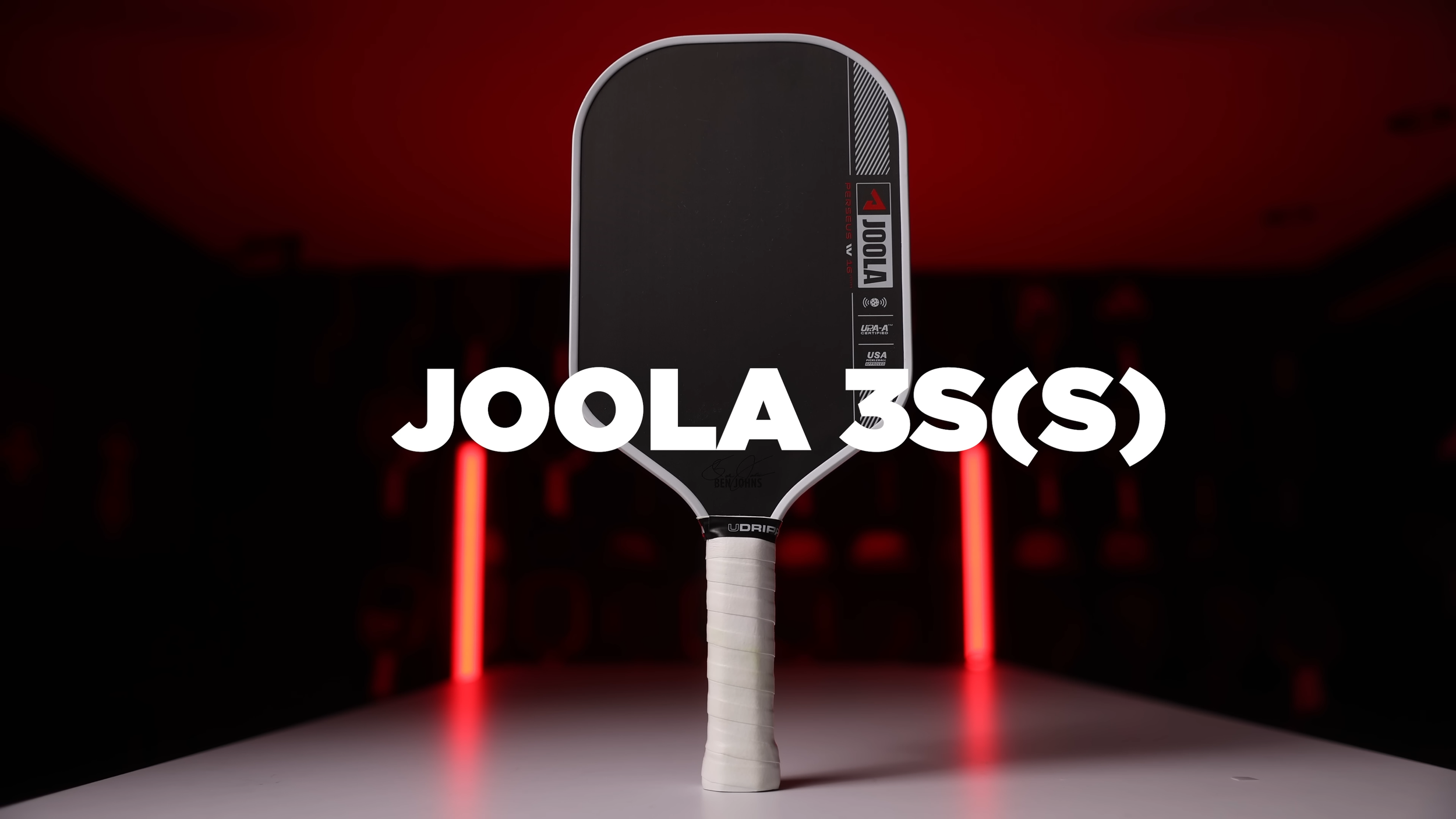 JOOLA 3S pickleball paddle displayed with dramatic red backlighting in a studio setting