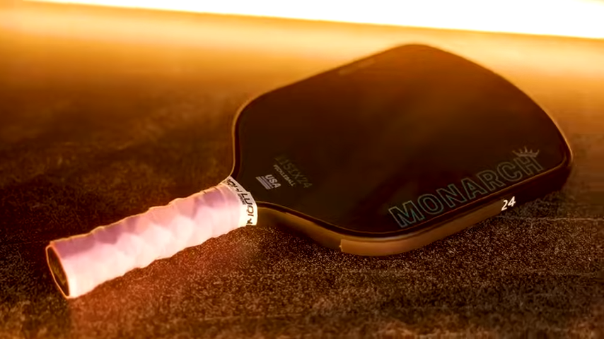 11SIX24 Monarch Jelly Bean pickleball paddle close-up with pink grip on dark textured surface