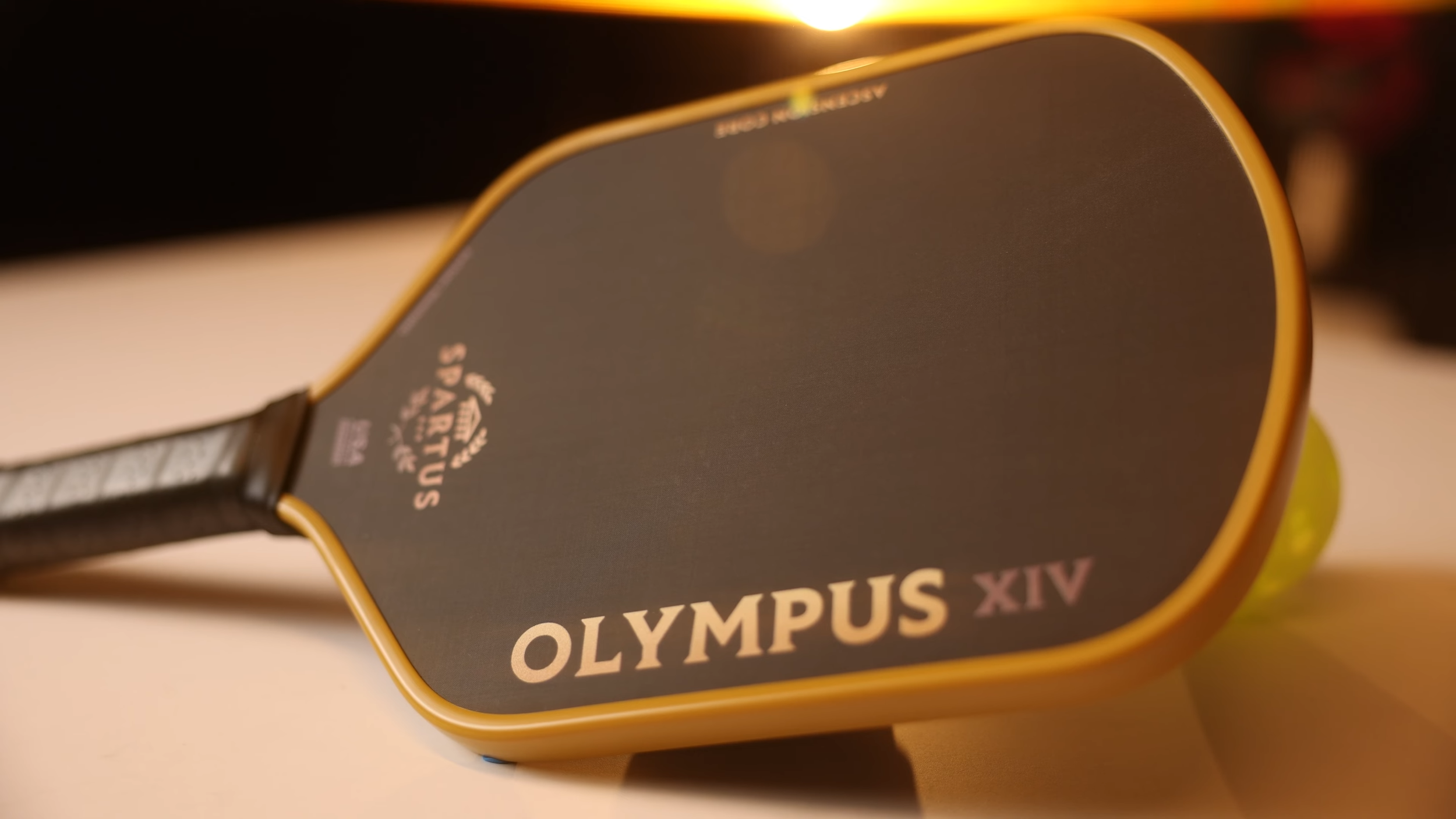 Spartus Olympus XIV pickleball paddle laying flat showing full face design and gold accents