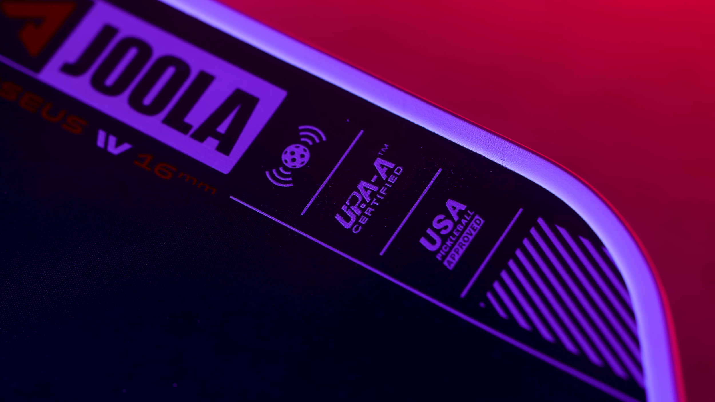 Close-up of JOOLA Perseus IV pickleball paddle showing UPA-A Certified and USA Pickleball Approved badges