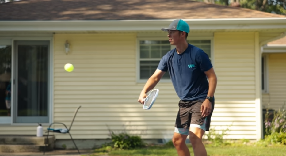 Player hitting a forehand with a Ronbus Quanta pickleball paddle on an outdoor court