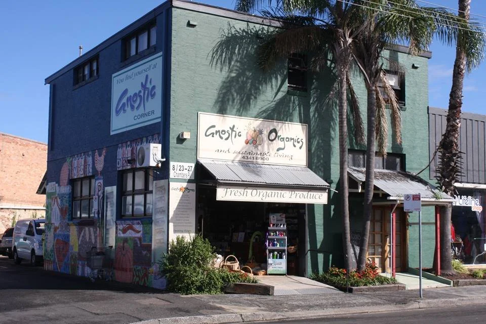 A multi-story building with a green facade, featuring signs for