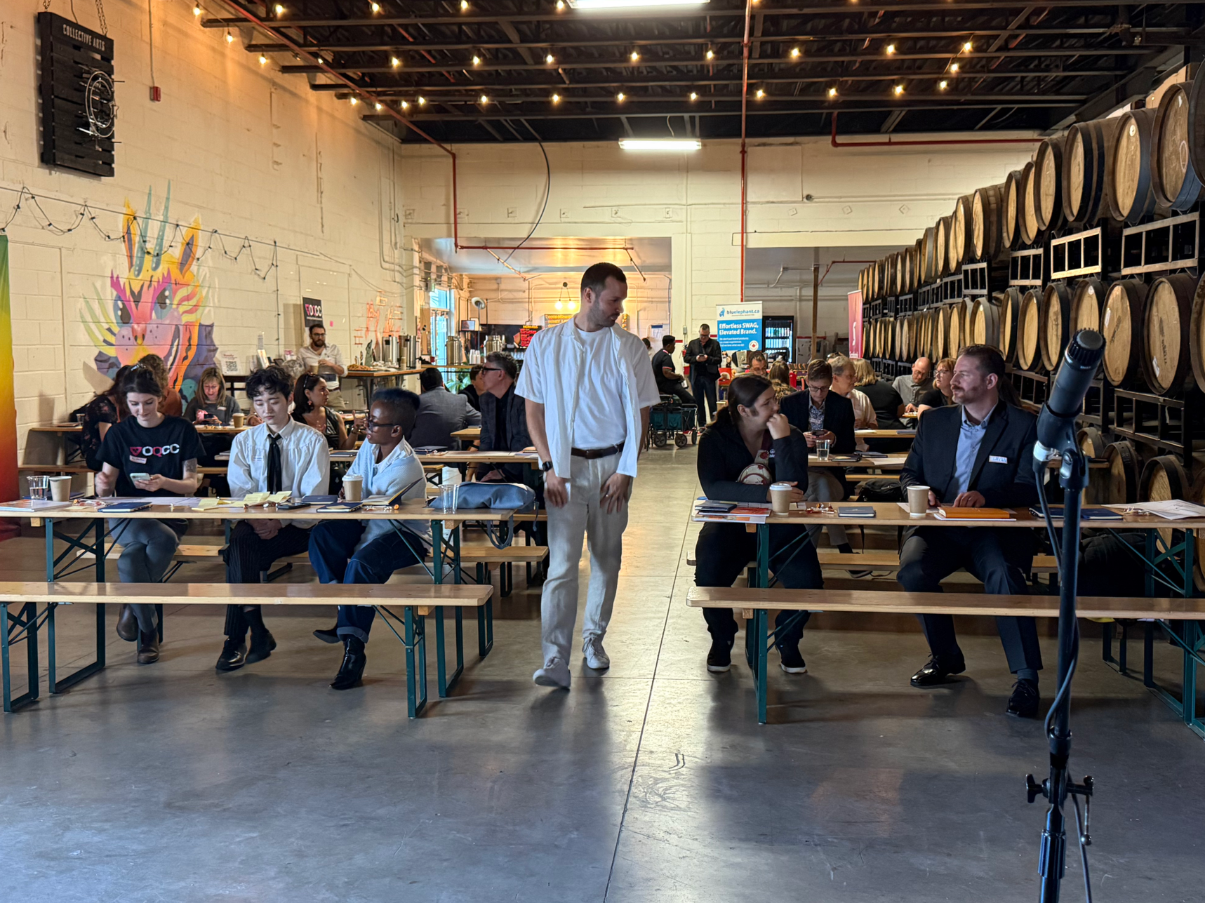 Andrew Charles Edwards, co-founder and CEO of designACE, wearing an all white outfit while hosting and facilitating an event.