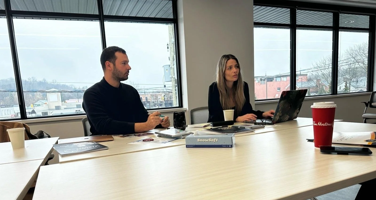 Founders of designACE, Andrew Charles Edwards and Christine Reynolds, sitting in an executive meeting.