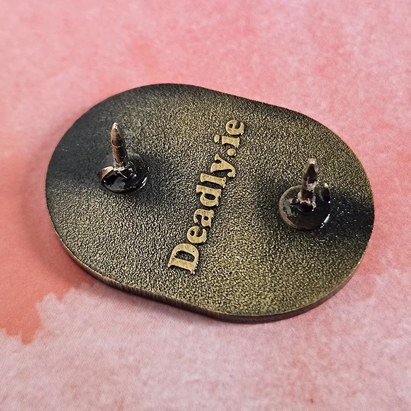 The back of the pin showing two pins and the 'deadly.ie' embossing on the back