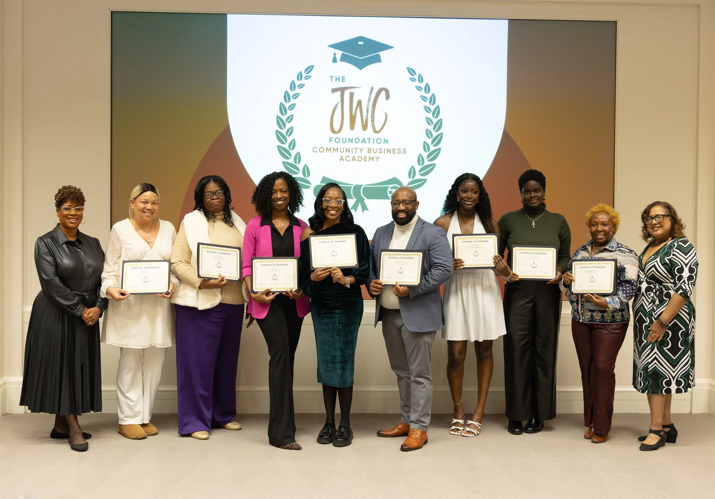 8 participants and 2 instructors taking a photo with their certificates of completion from our incubator program