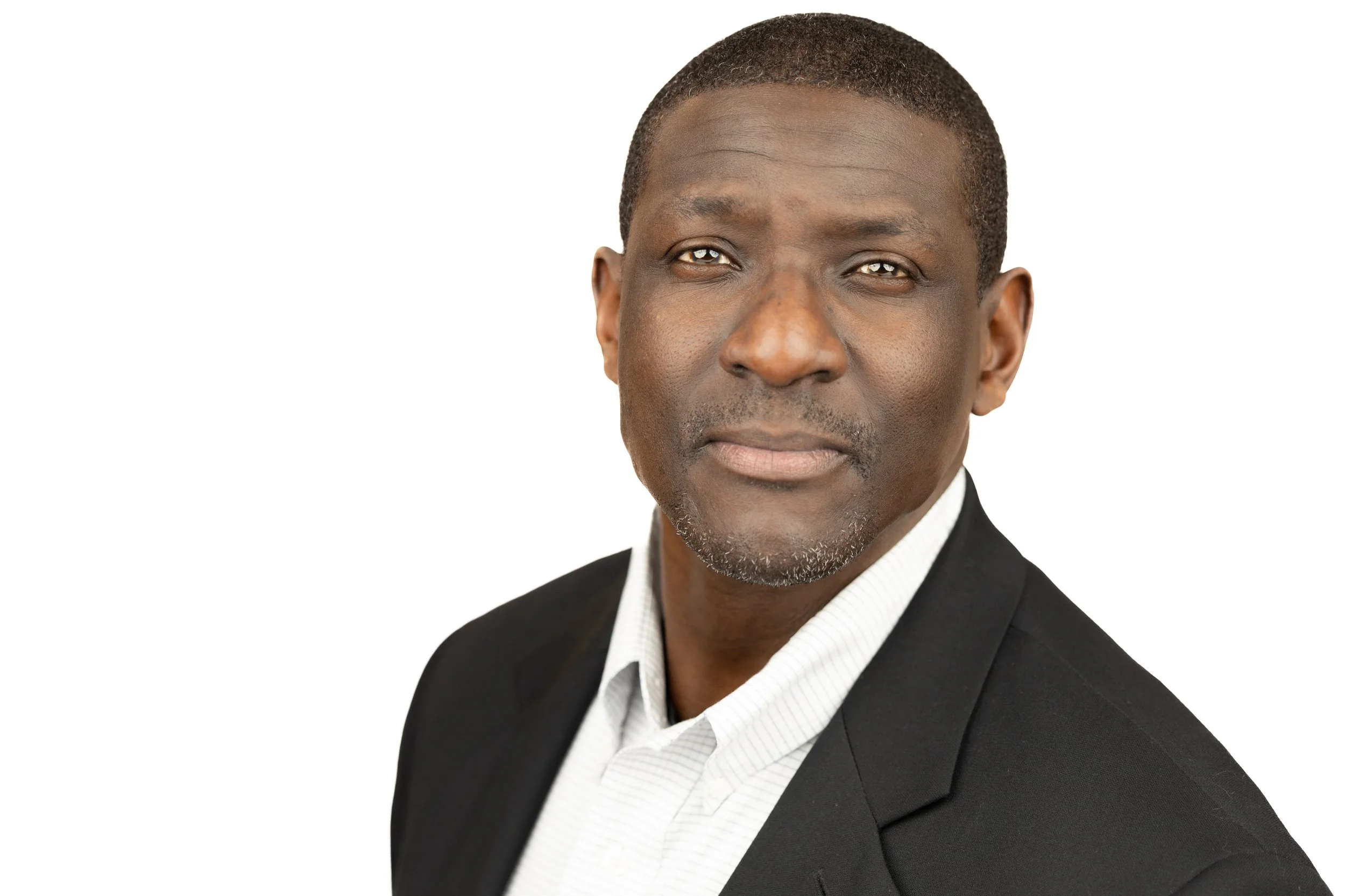 Portrait of a middle-aged African American man wearing a black suit and white shirt, against a plain white background.