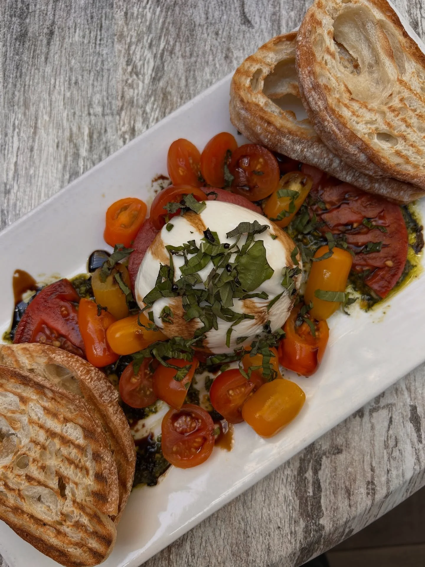 When life gives you tomatoes… add burrata.
Local heirloom tomatoes, fresh creamy burrata, pistachio pesto—one of our favorite apps at Napa Flats.
Trust us, you need to try this one.