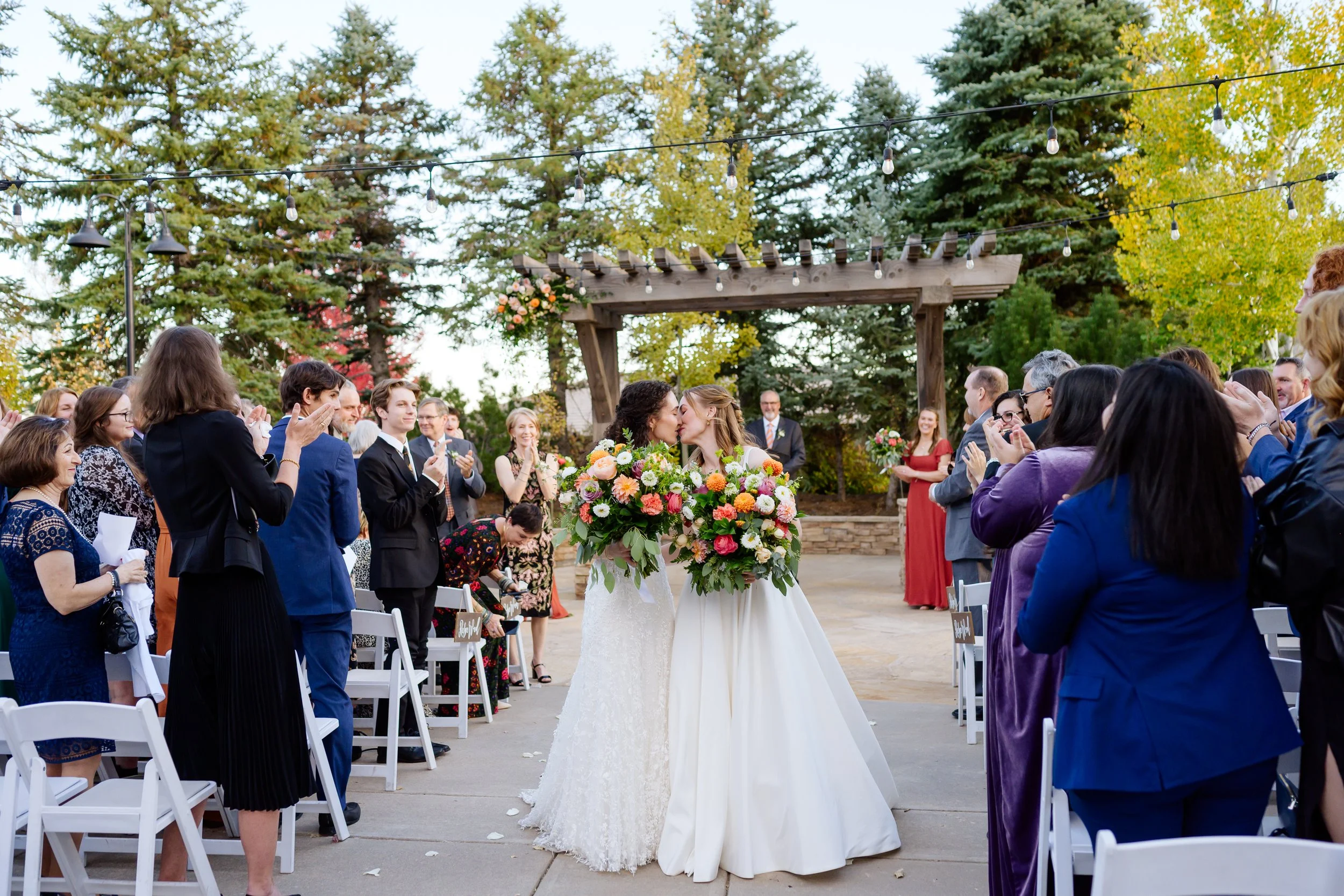 At Ken Caryl an LGBTQ+ couple embraces after saying "I Do", captured by queer photographer, Catherine Norwood Photography