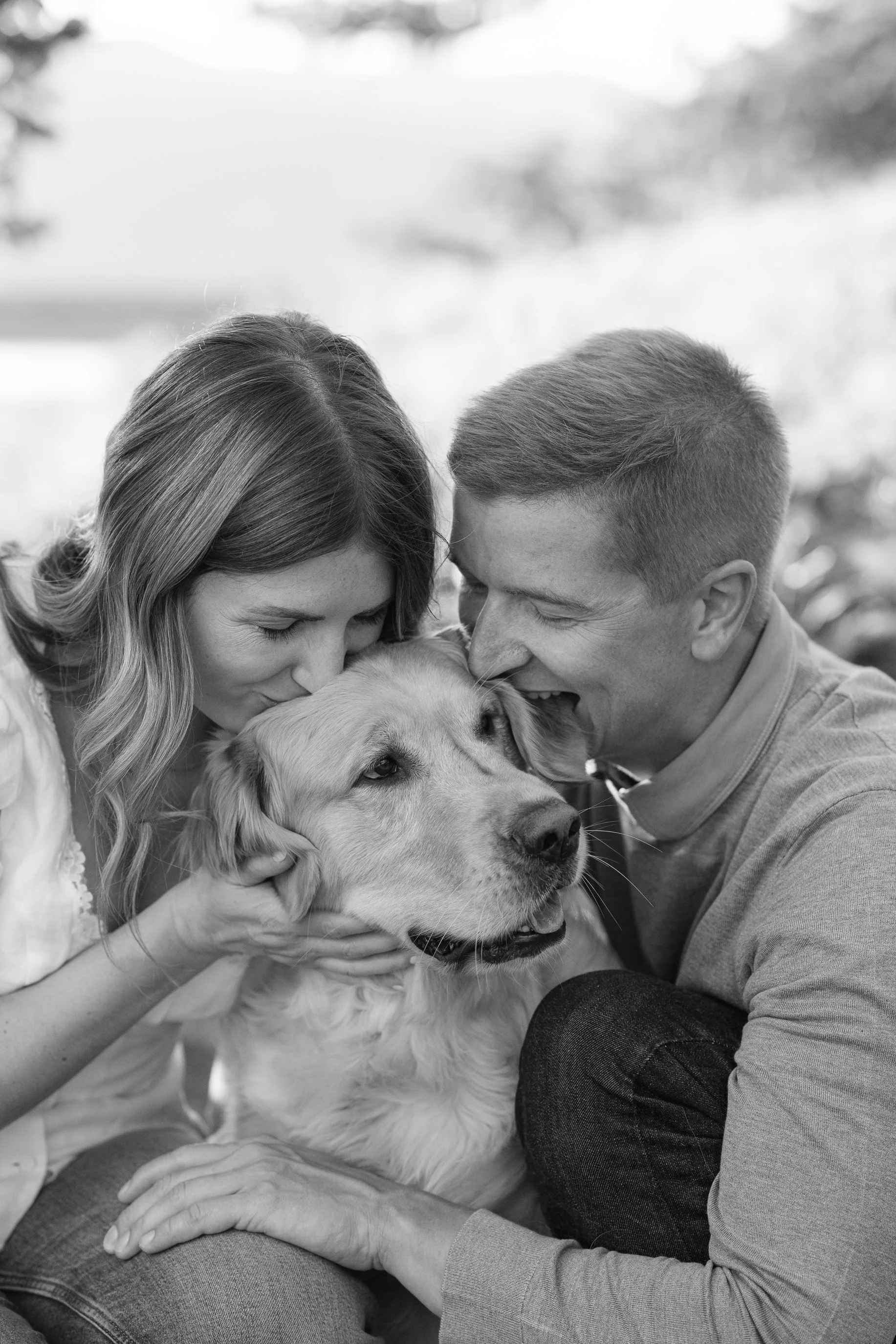 Fiances cuddle their golden retriever dog in the trees for an colorado engagement photo near Copper Mountain and Vail Colorado while the leaves change