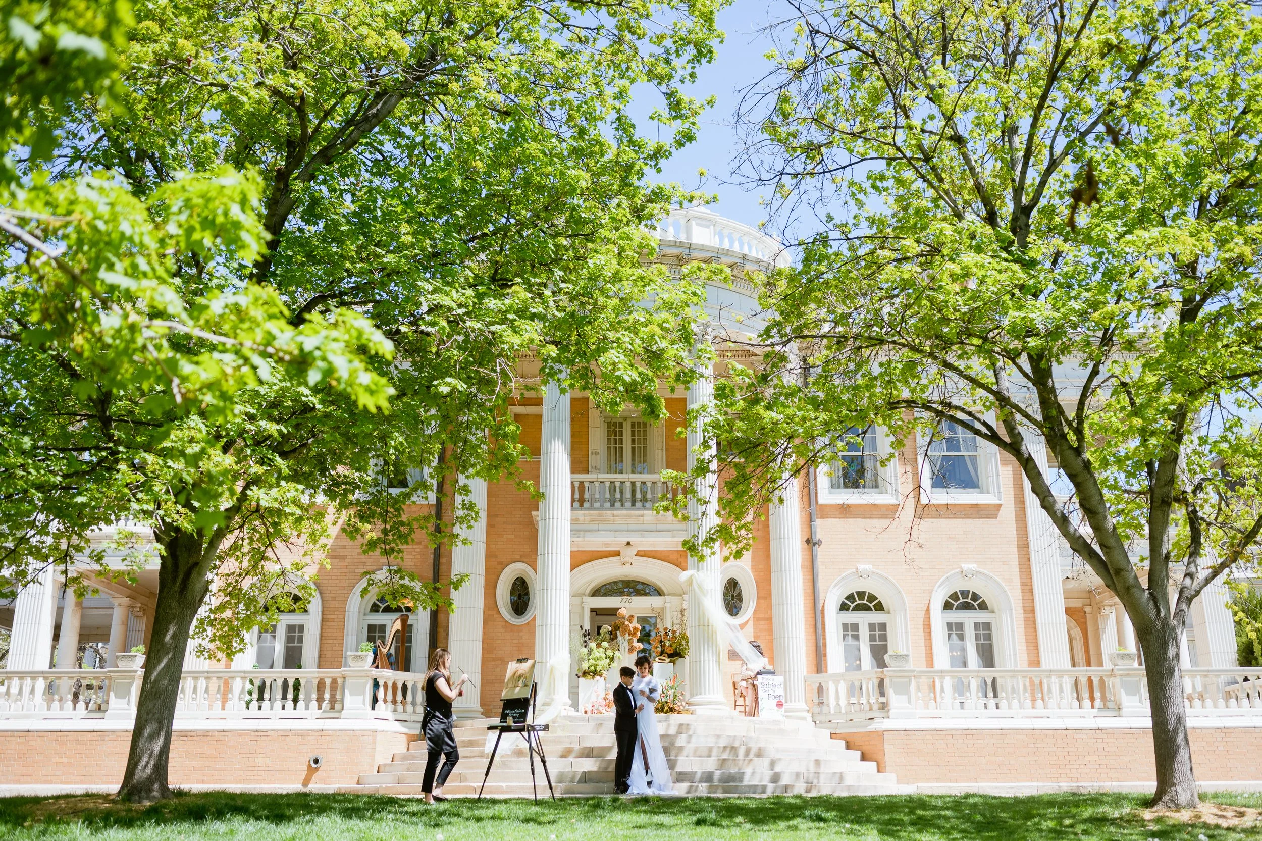 At the Grant Humphreys Mansion Queer couple poses outside of a historic building in Denver, Colorado after getting married