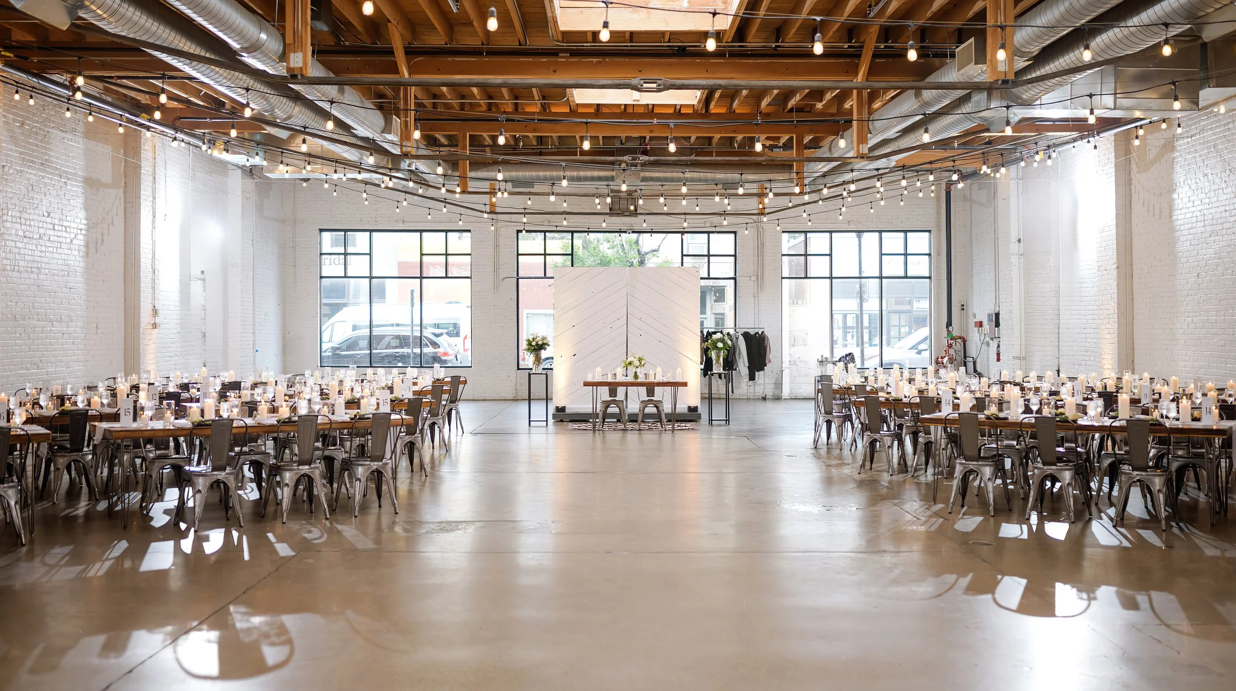 Skylight, an ADA Denver venue, featuring a lit up reception space in this industrial venue in Denver, Colorado shows wedding day set up