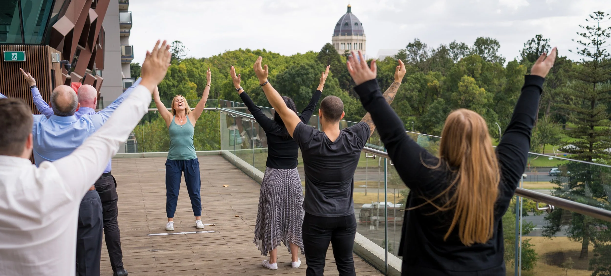 Qigong teacher leading students through a group Qigong practice outdoors.