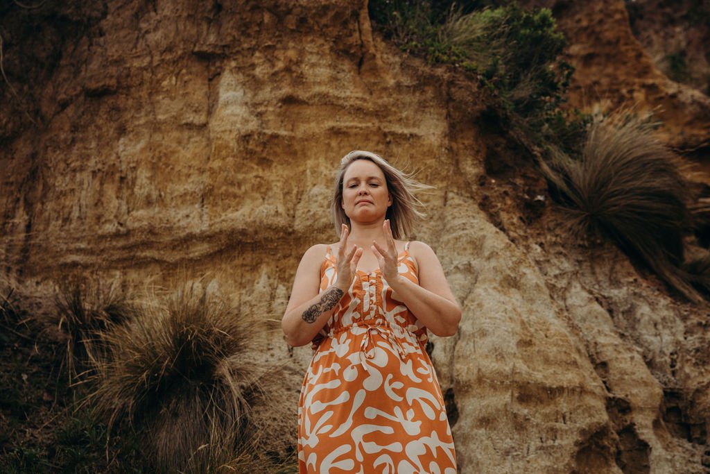 Nicole Lee practising Qigong outdoors, focusing on energy awareness and hand positioning