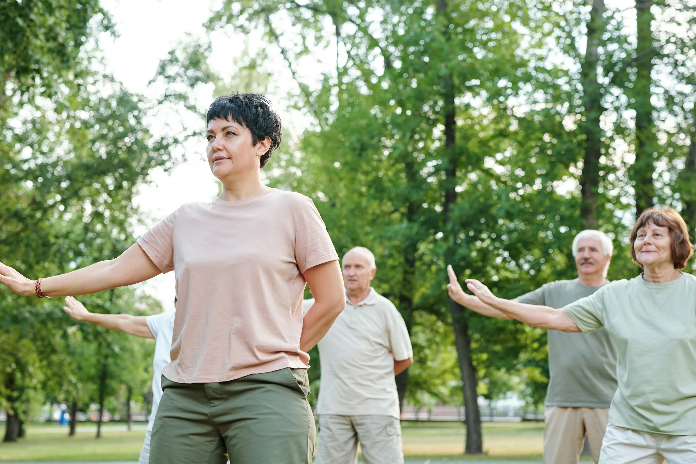 Beginner Qigong practice outdoors showing slow movement, breath and energy cultivation