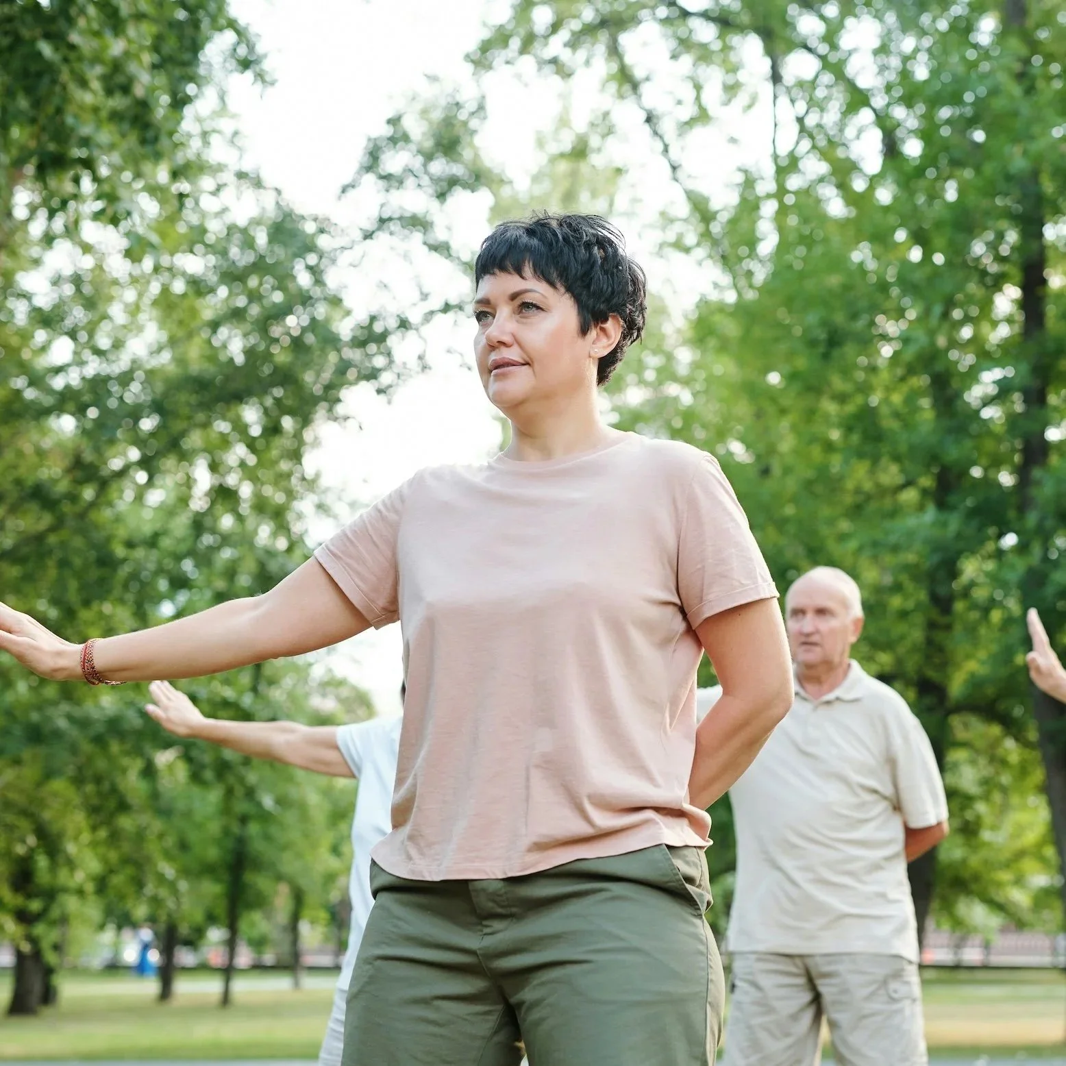 Woman practising Qigong outdoors in a park