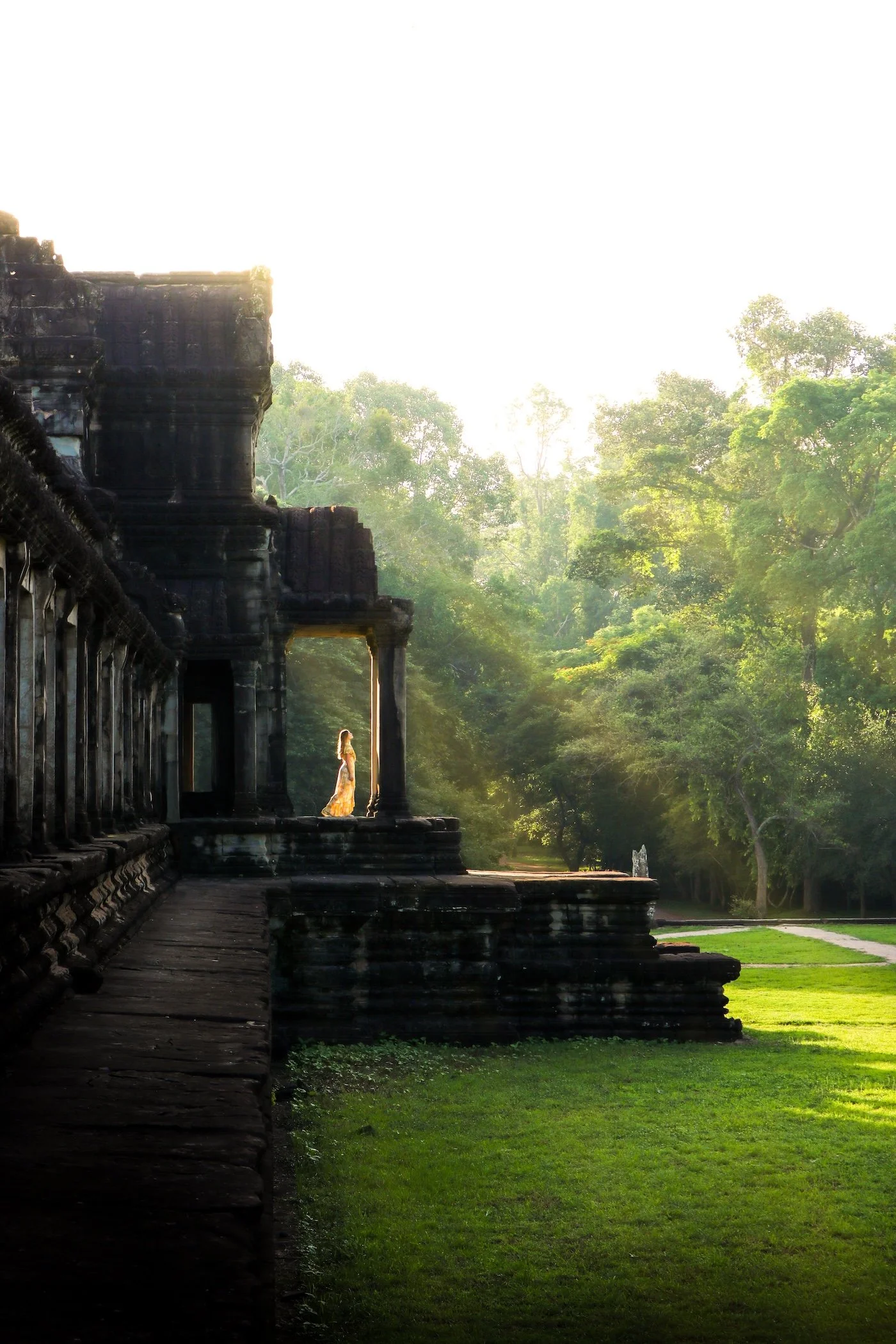 Person practising Qigong in the grounds of an ancient temple surrounded by trees and natural landscape
