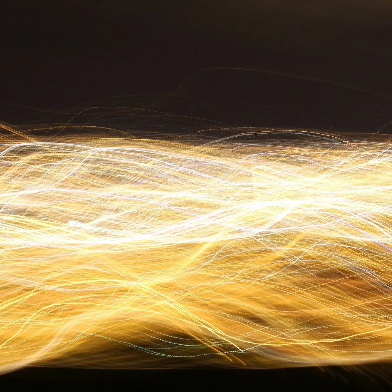 Abstract image of flowing golden lines of light against a dark background