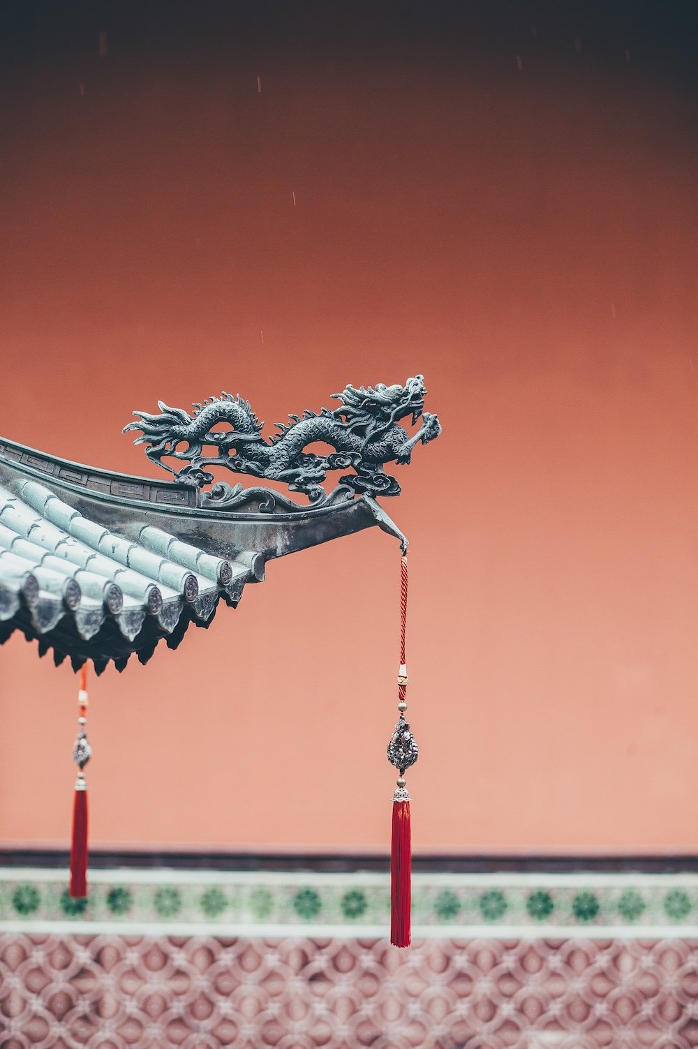 Traditional Chinese temple roof ornament featuring a carved dragon against a warm evening sky