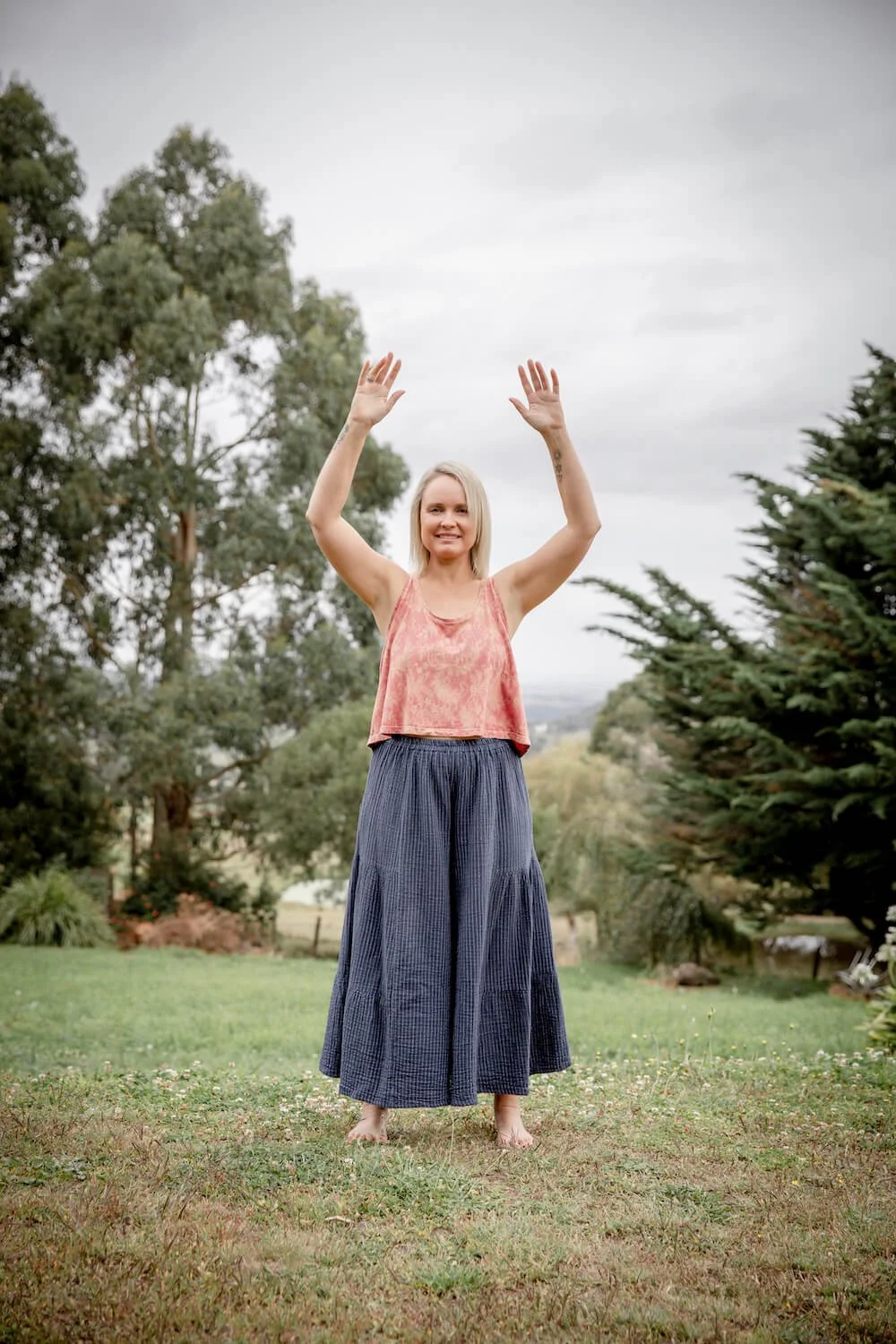 Qigong teacher Nicole Lee practising a foundational Qigong exercise outdoors to support the development of a consistent Qigong practice.