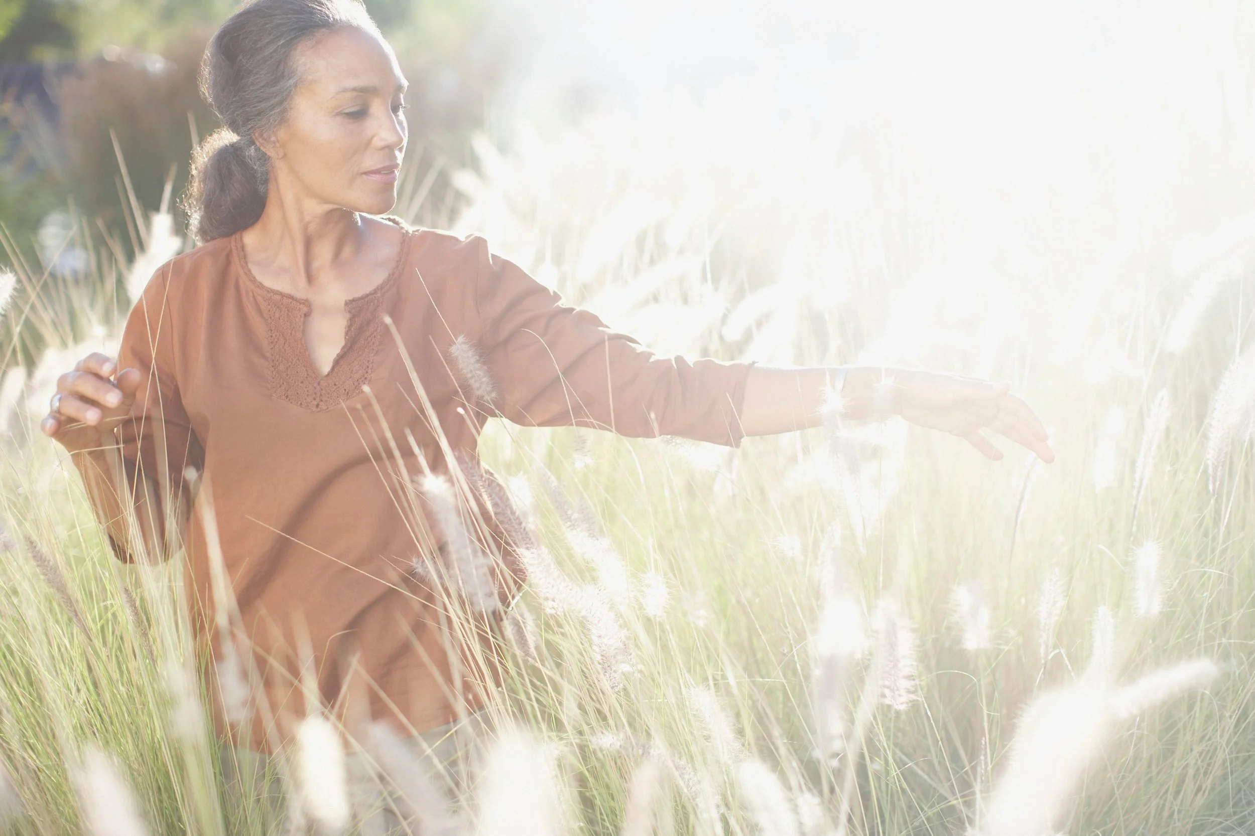 Woman practising Qigong outdoors in soft natural light, representing inner calm, embodiment, and the long-term benefits of consistent Qigong practice.